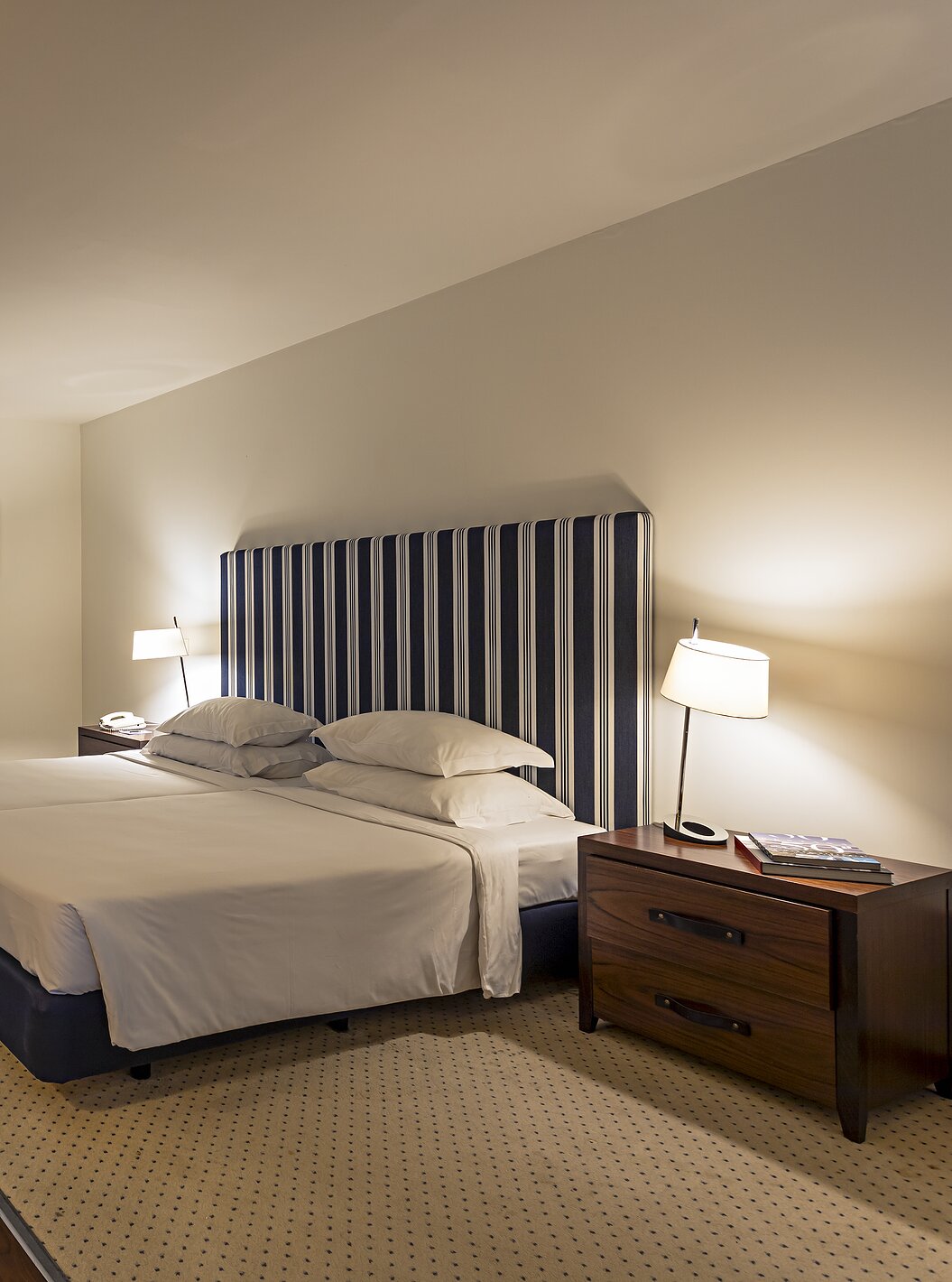 De Cliff Suite T2 in Pestana Alvor Praia heeft een grote kamer met tweepersoonsbed, twee schilderijen en een dressoir met tv