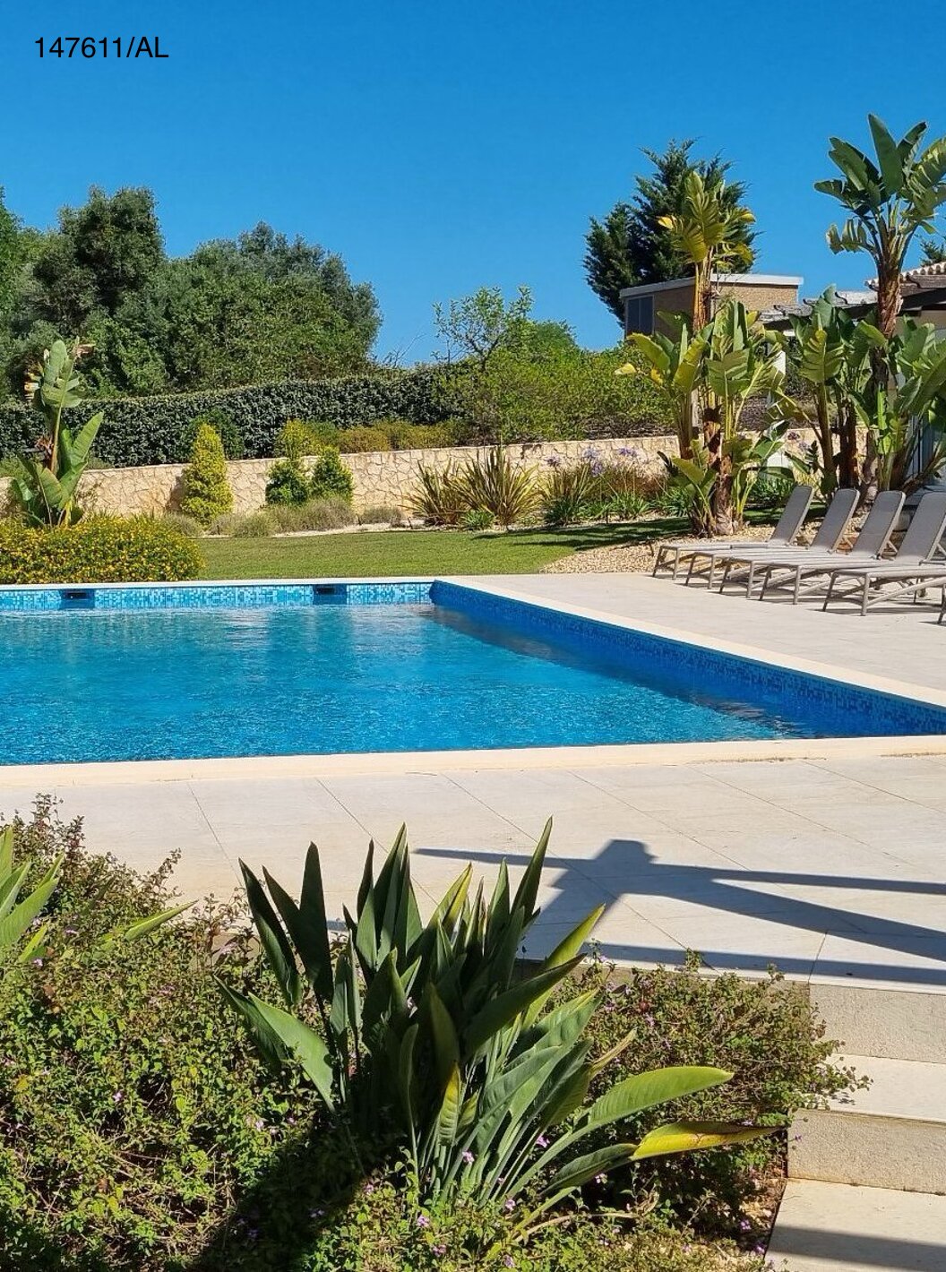 De villa Pestana Carvoeiro Golf V5 Superior heeft een buitenruimte met een zwembad, een gazon en ligstoelen