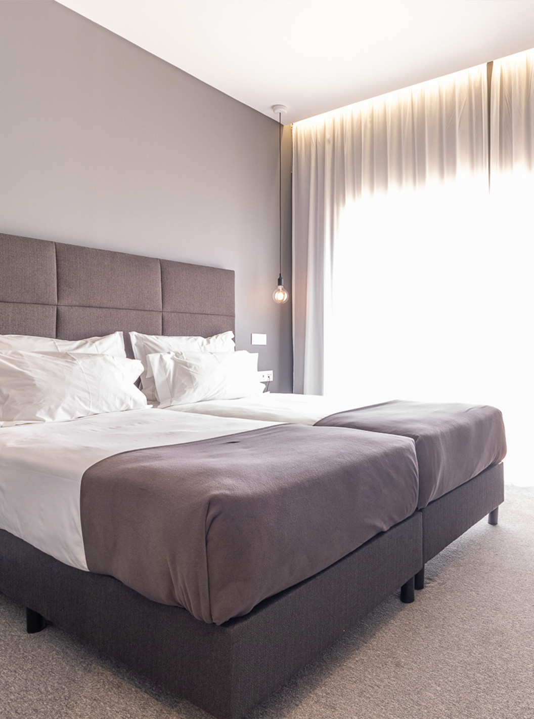 Klassieke kamer in Pestana Gramacho Residences met twee bedden, gordijnen en tafel met bloemen