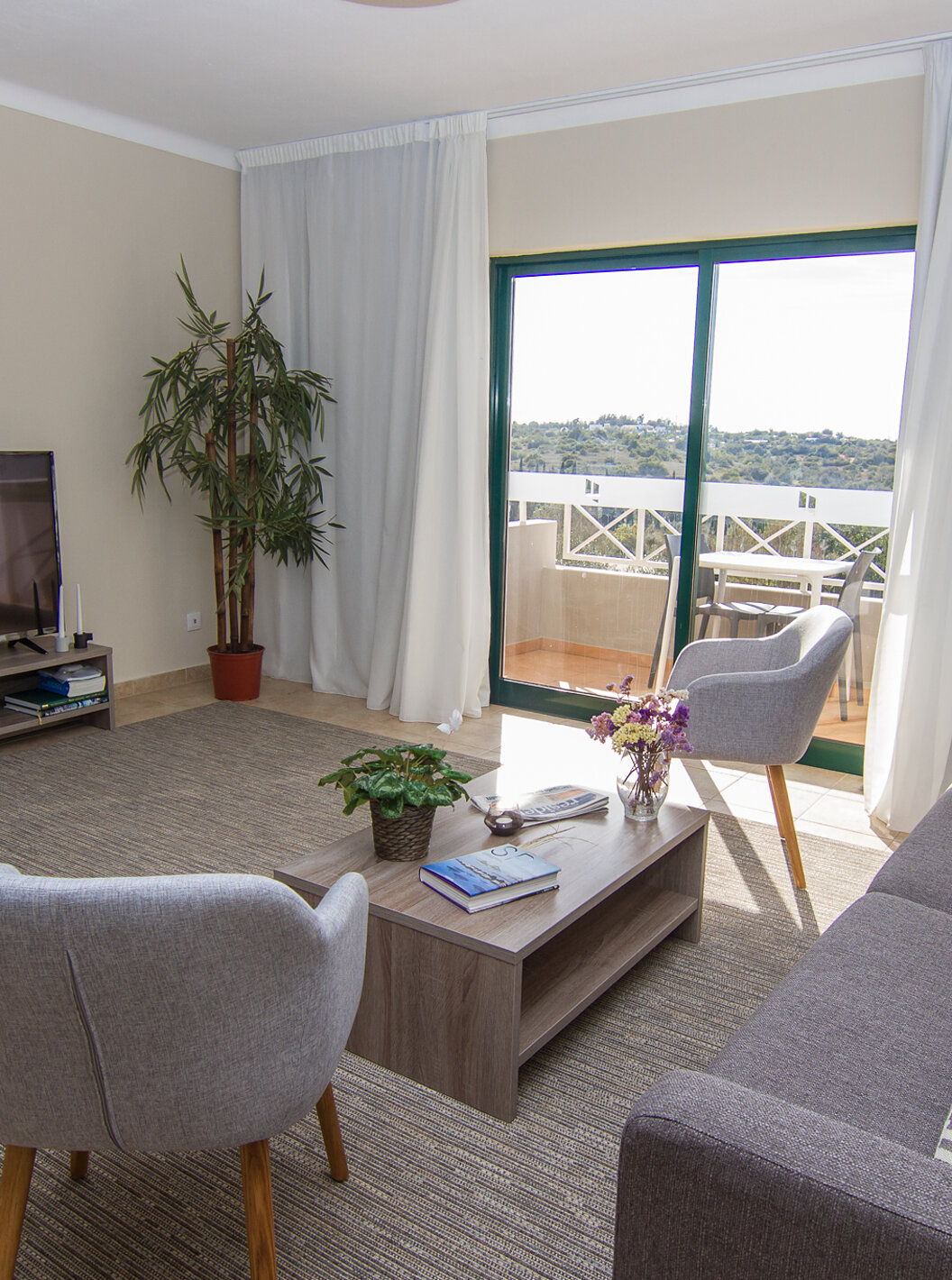 De Villa V3 van Pestana Gramacho Residences heeft een woonkamer met banken, televisie en een raam met balkon