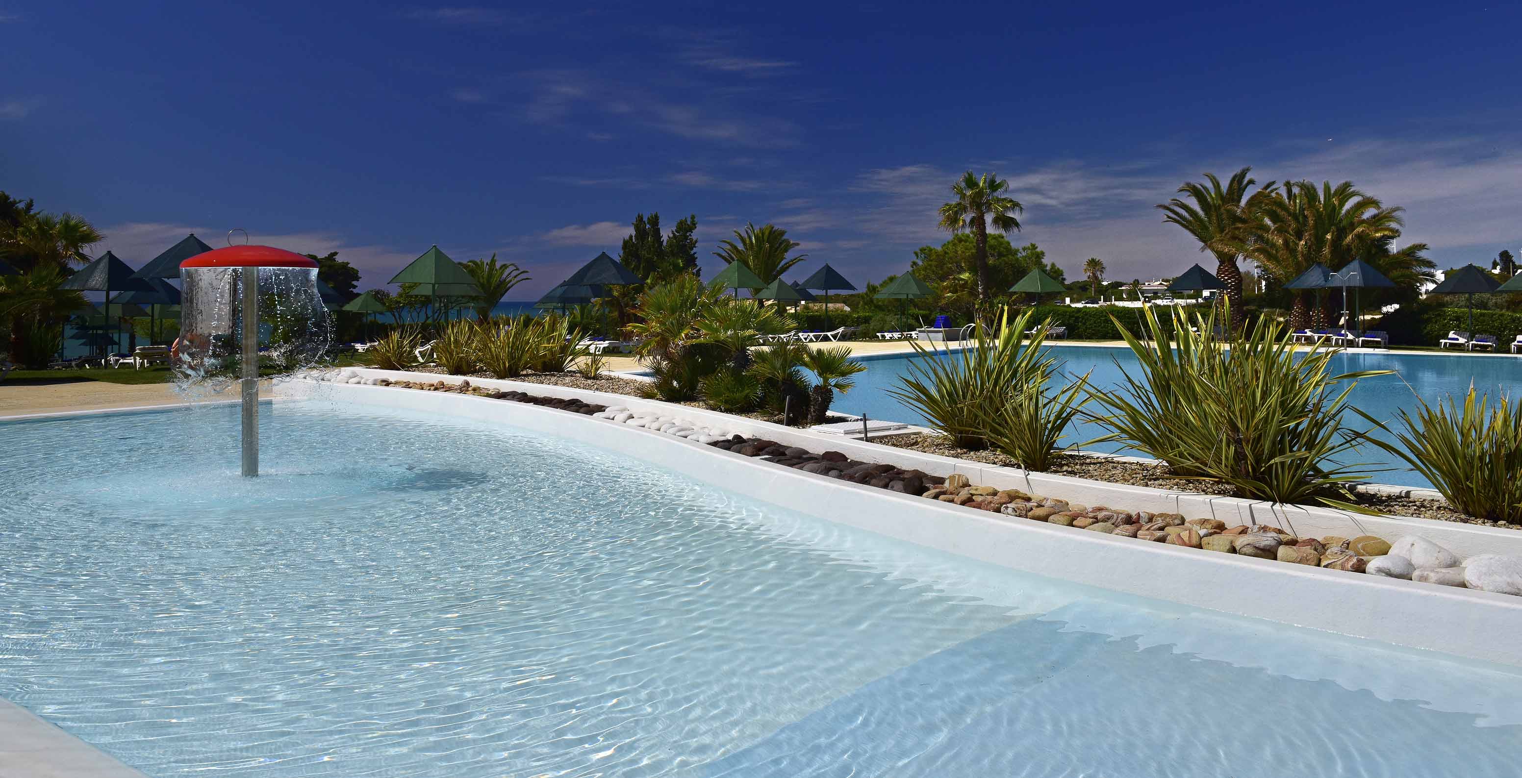 Pestana Viking, 4-sterrenhotel in Alvor, heeft een kinderzwembad en een volwassenen zwembad met ligstoelen eromheen