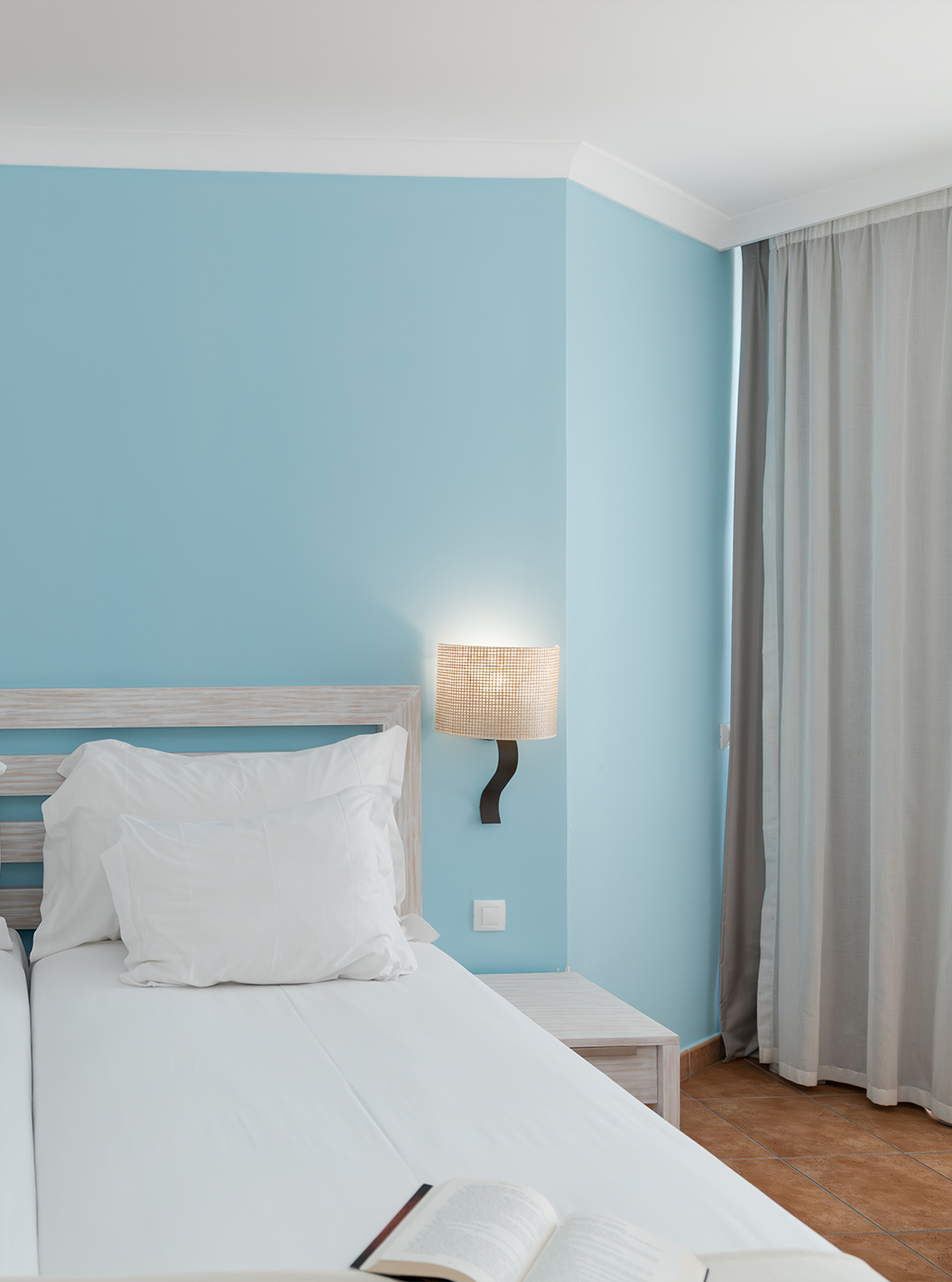 De Deluxe Zeezicht van Pestana Viking heeft twee bedden, twee nachtkastjes en blauw behang