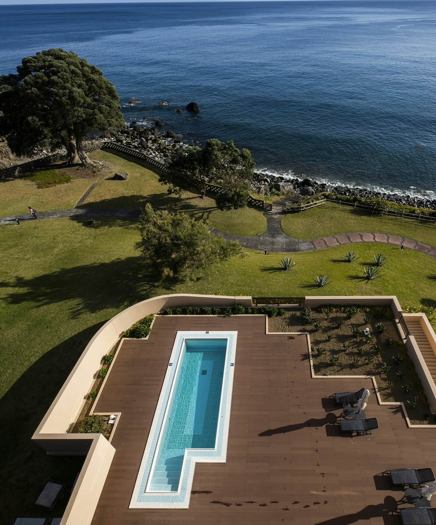 Zwembad van Pestana Bahia Praia op houten terras met uitzicht op zee en groene omgeving
