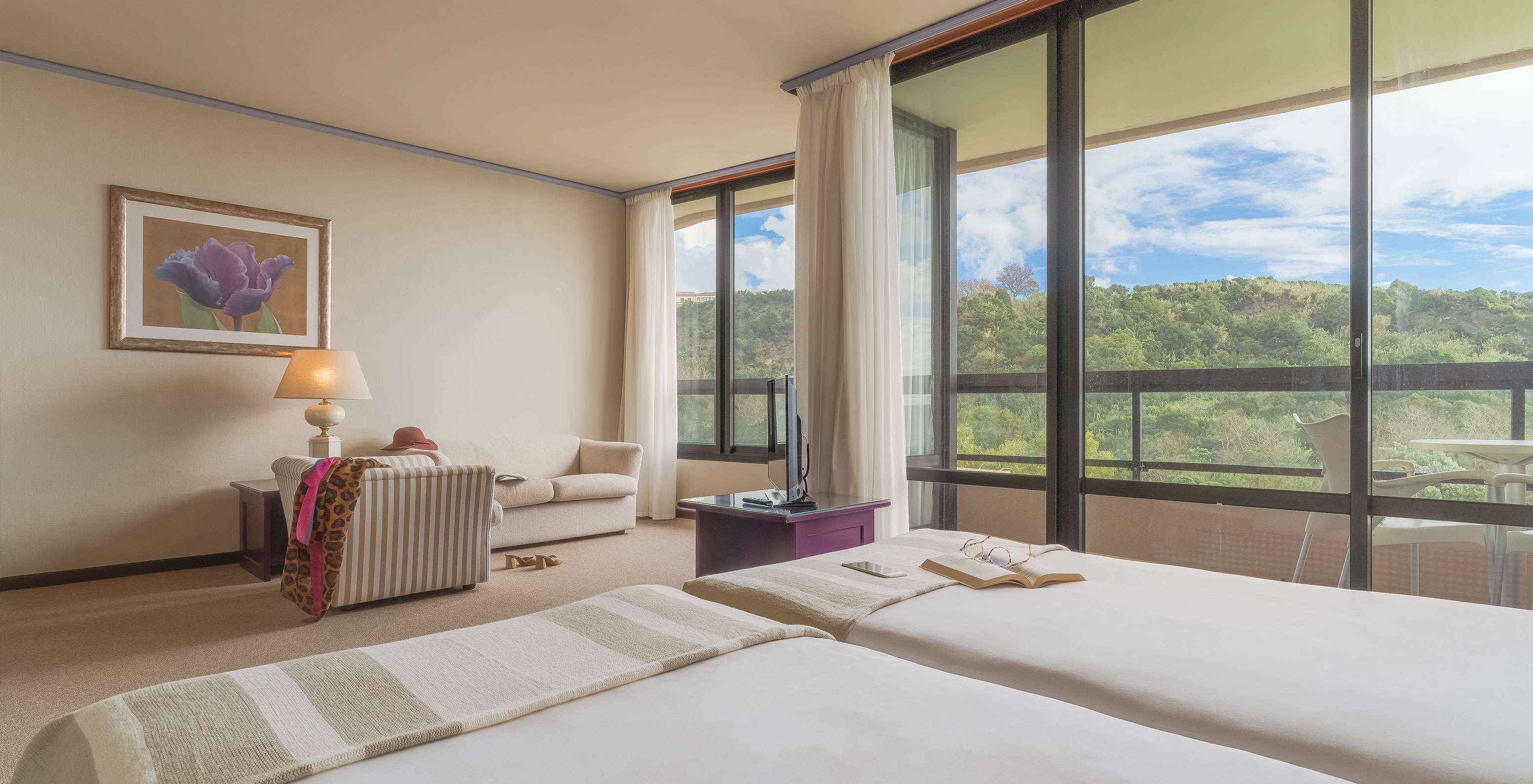 Junior Suite Tuinzicht van Pestana Bahia Praia heeft mooi uitzicht op groene landschap met toegang tot balkon