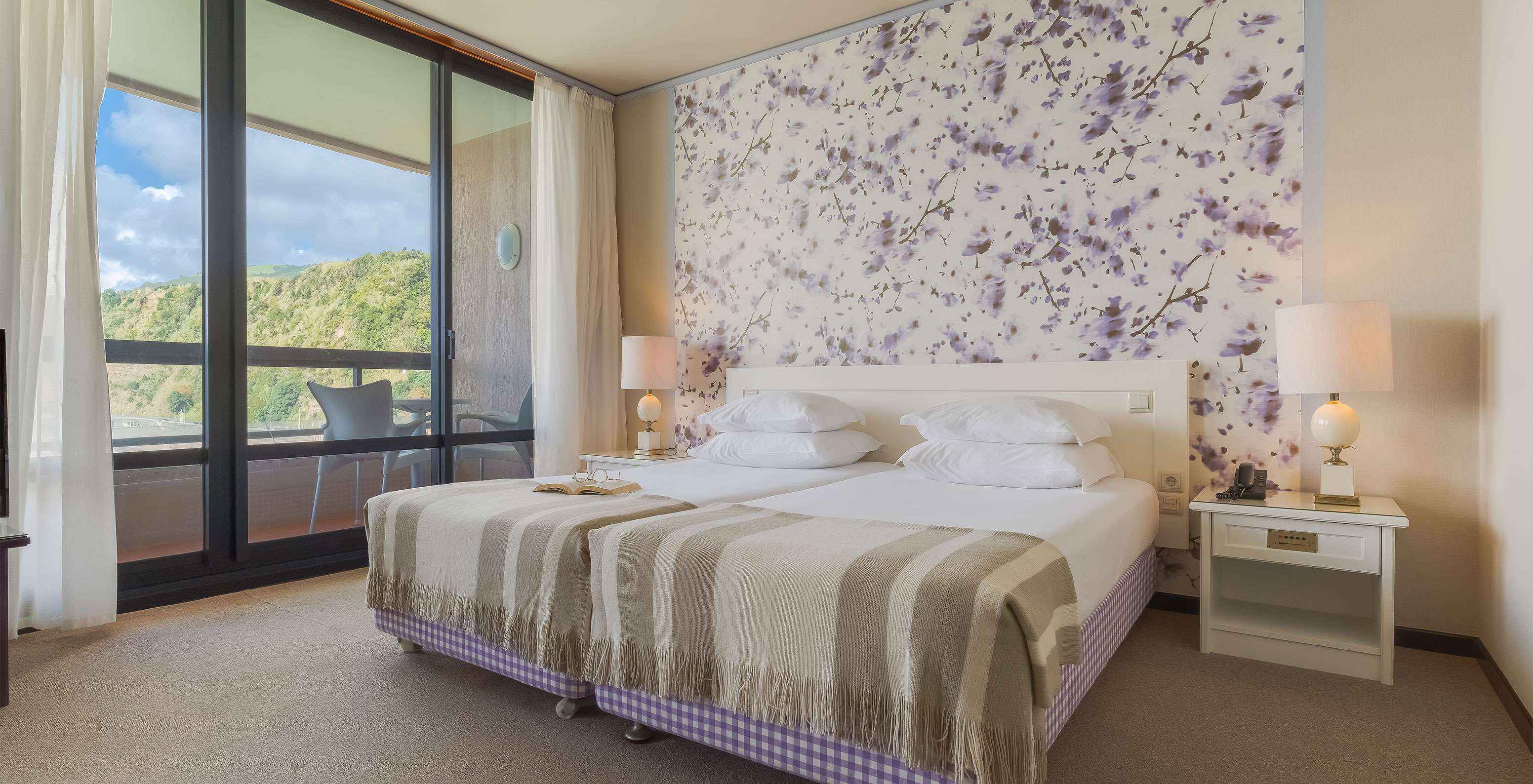 Junior Suite Zeezicht van Pestana Bahia Praia heeft ruime ruimte met twee eenpersoonsbedden, een bank en stoel