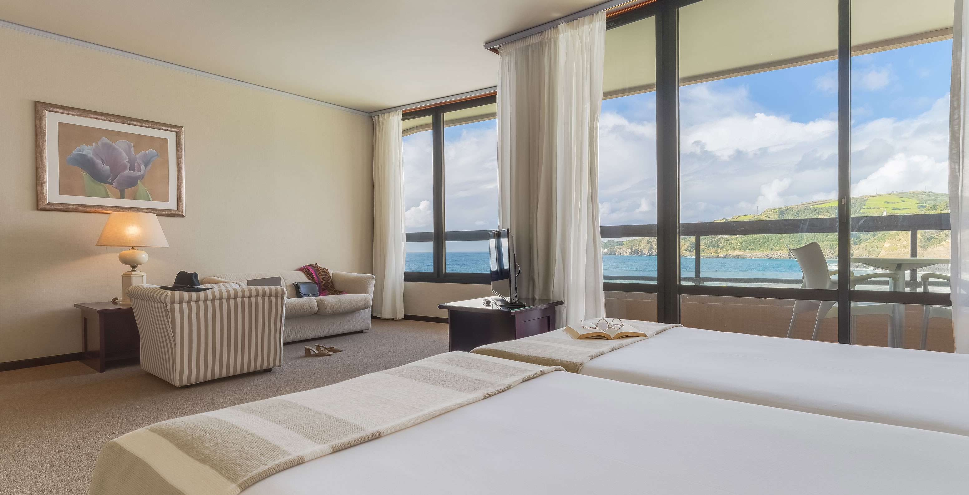 Junior Suite Zeezicht van Pestana Bahia Praia heeft mooi uitzicht op groene landschap en zee met toegang tot balkon