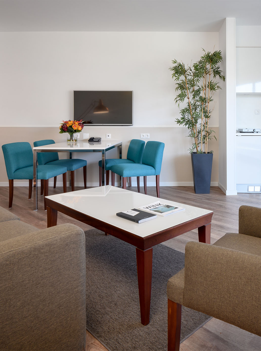 De Deluxe Suite van Pestana Cascais heeft een woonkamer met bank, salontafel, eettafel en televisie