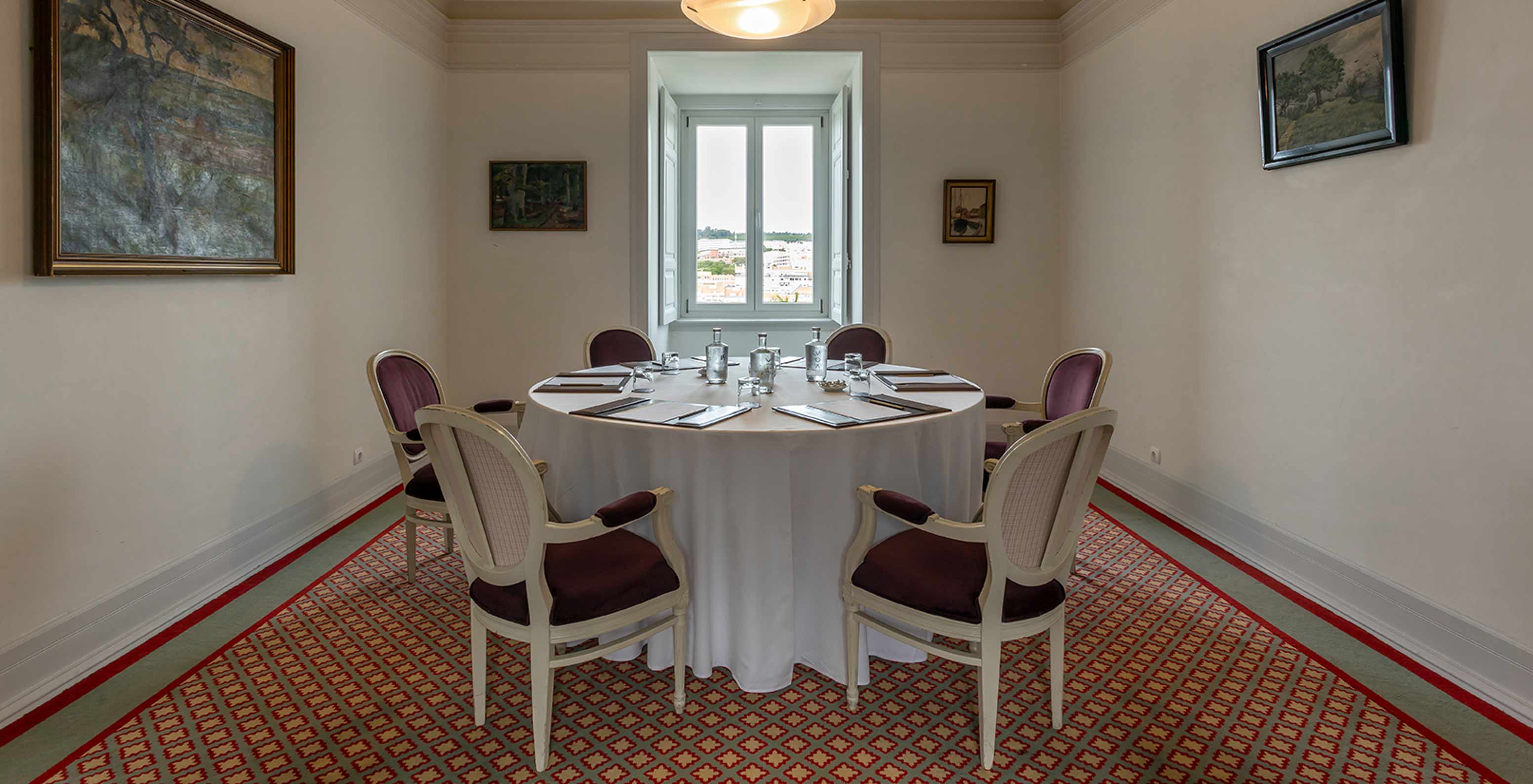 Pestana Palace Lisboa heeft een vergaderzaal met een ronde witte tafel omringd door paarse stoelen	