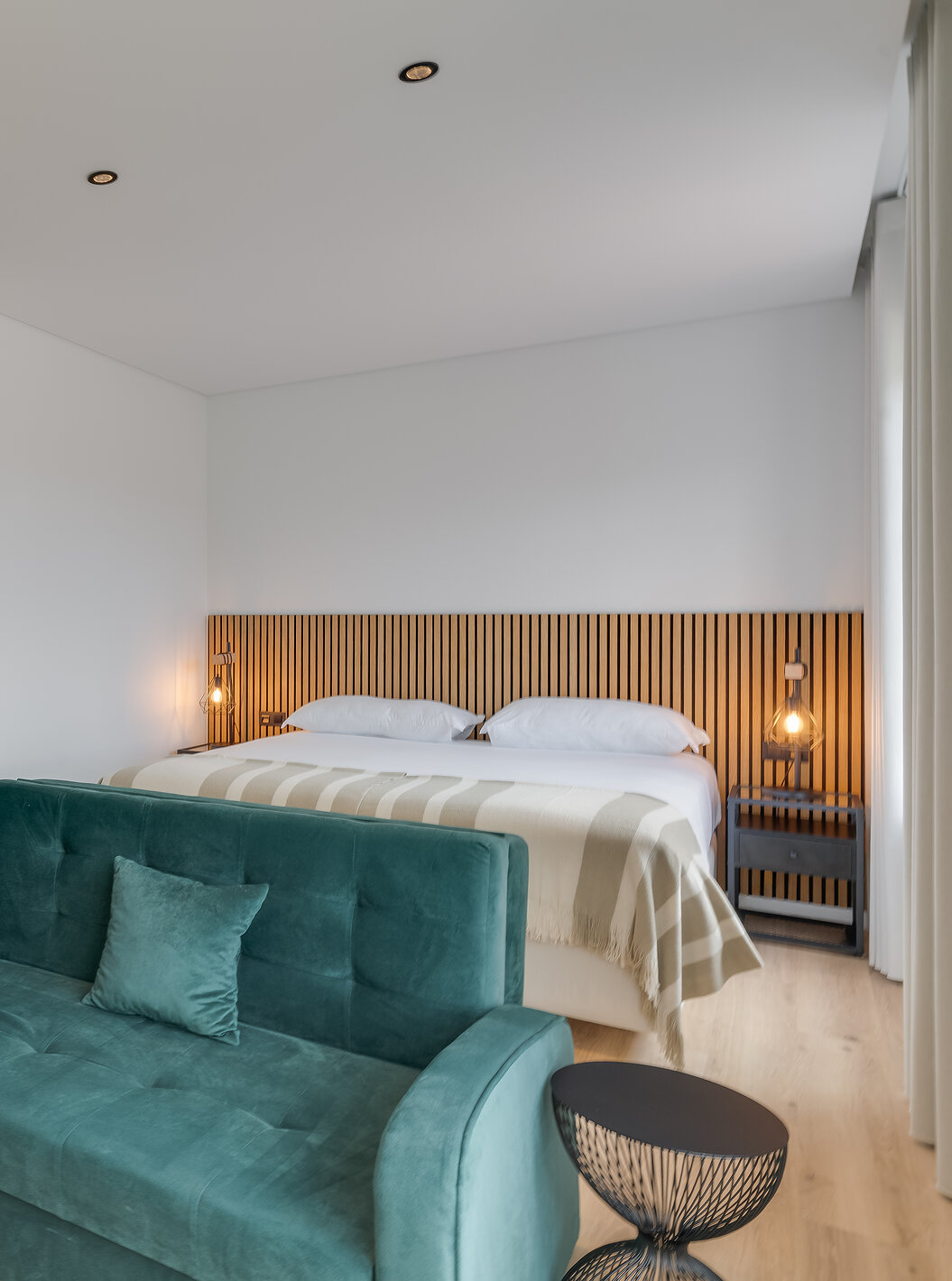 De Familiale met Balkon - Clubhouse van Pestana Sintra Golf heeft een tweepersoonsbed met houten hoofdbord, bank en tafel