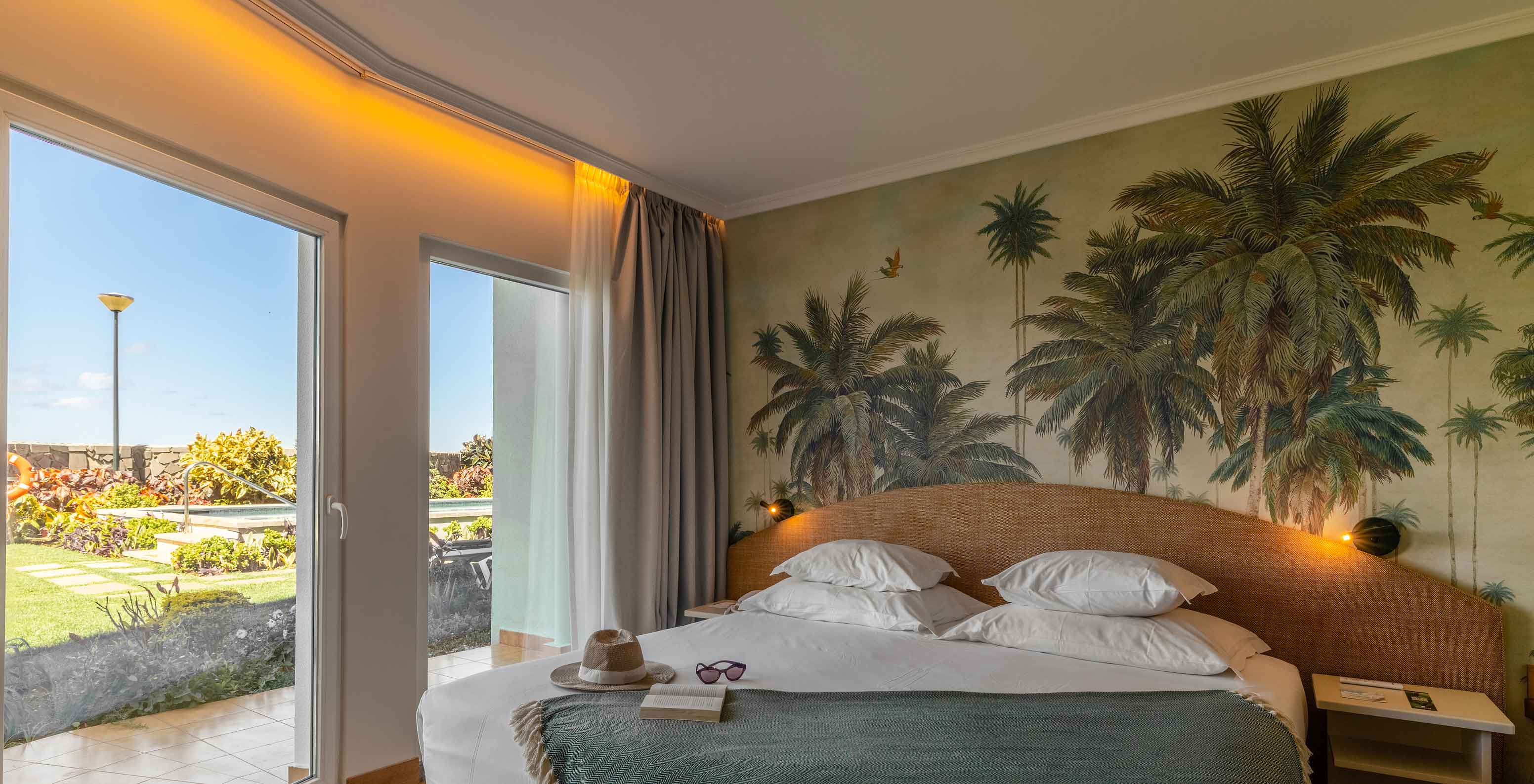 De Junior Suite Sea View van het Pestana Ocean Bay All Inclusive heeft een tweepersoonsbed en behang