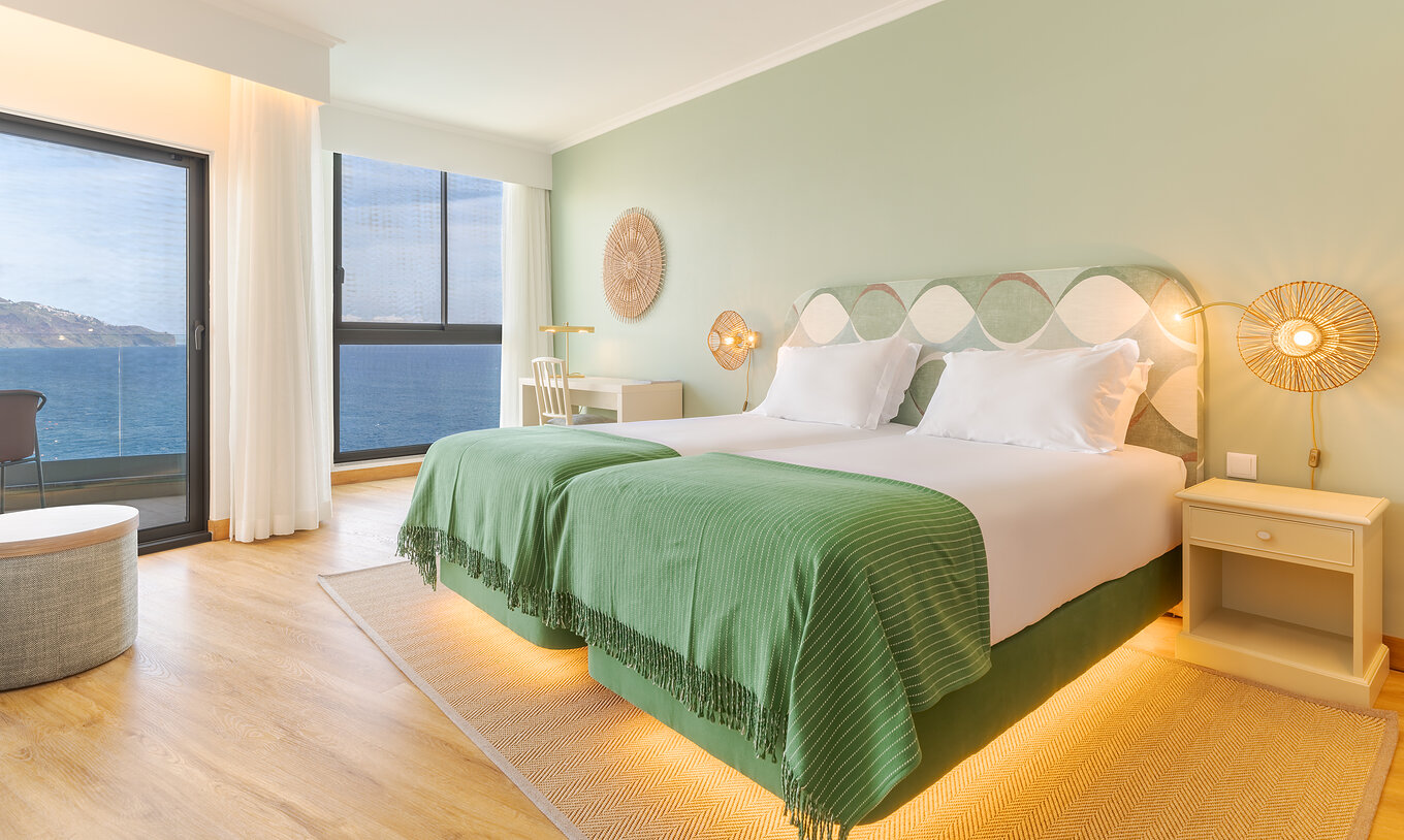 De Superior Sea View kamer van Pestana Vila Lido Madeira heeft groene tinten, twee eenpersoonsbedden, bureau en balkon