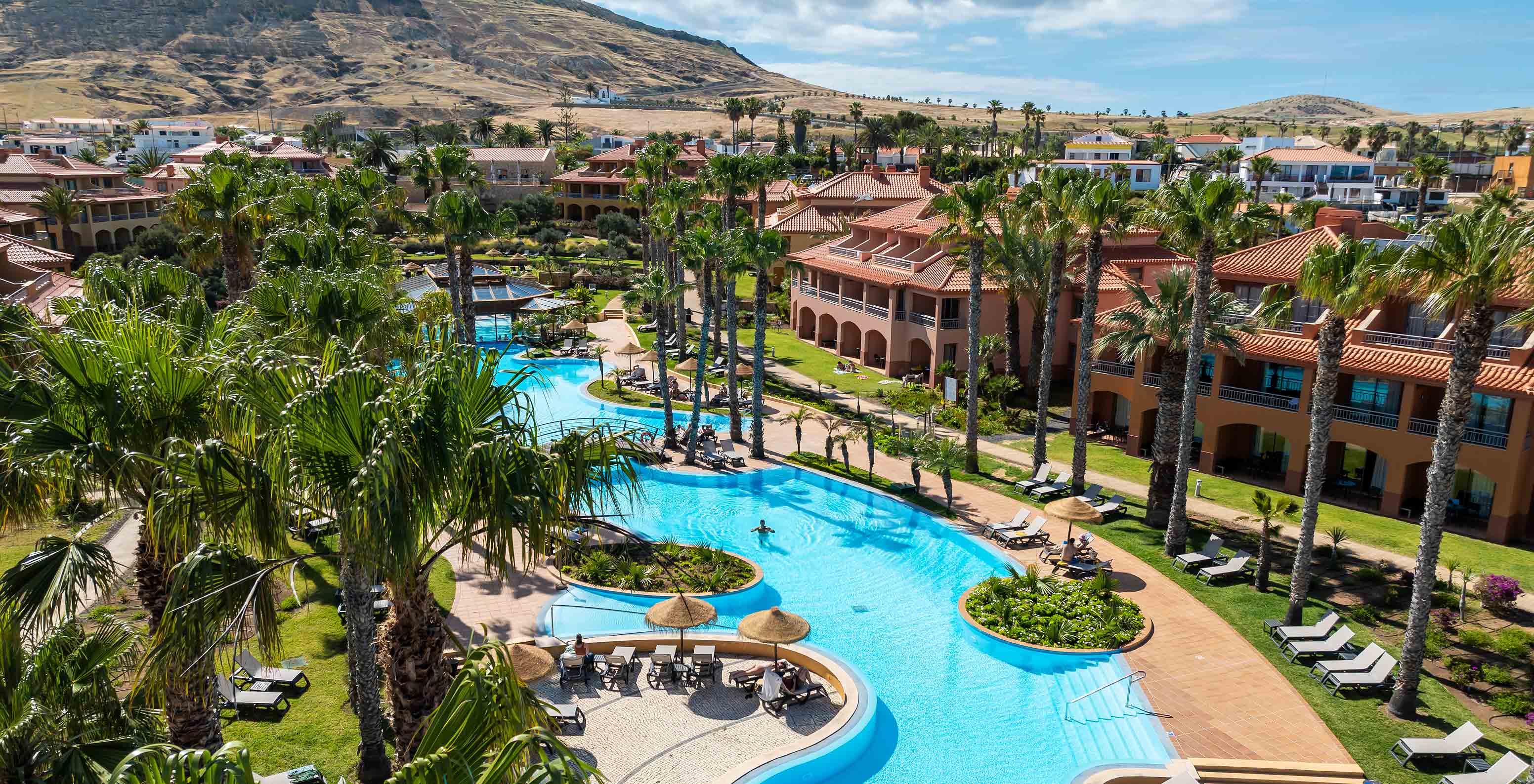 Indeling van de villa’s van Pestana Porto Santo All Inclusive, omgeven door begroeiing en met het buitenzwembad in het midden