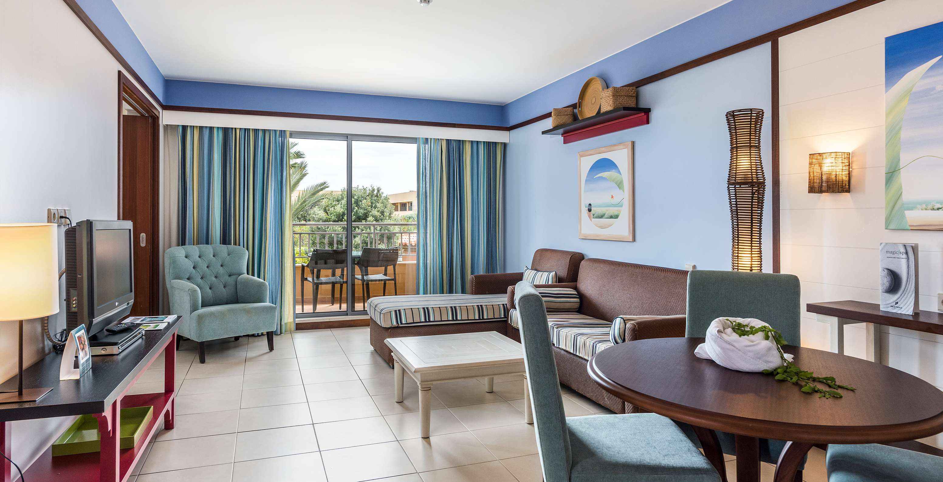 De Suite Appartement T2 van Pestana Porto Santo All Inclusive heeft een woonkamer met twee banken televisie en balkon