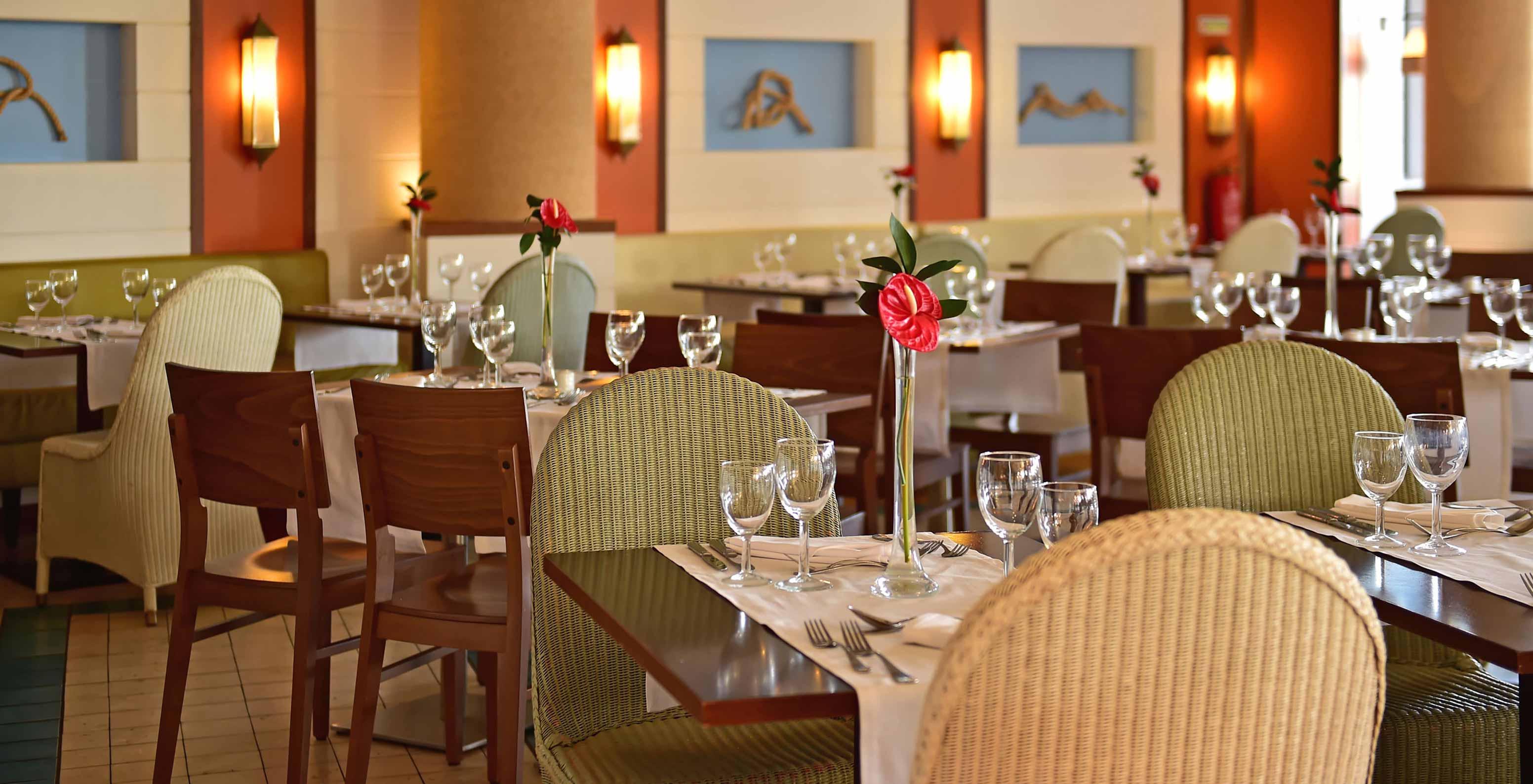 Restaurant Marés, 5-sterrenresort in Porto Santo heeft een ruimte met groene stoelen en houten tafels