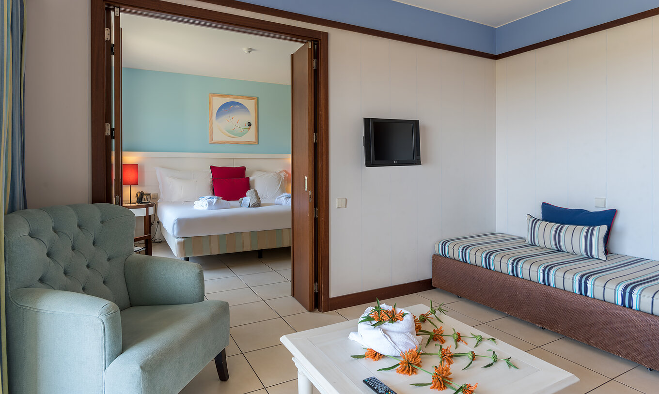 De Suite Appartement T1 van Pestana Porto Santo All Inclusive heeft een slaapkamer met tweepersoonsbed en een woonkamer