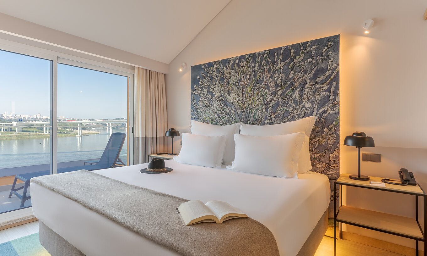 De Suite Douro van Pestana Douro Riverside heeft een tweepersoonsbed met nachtkastje en balkon met uitzicht op de rivier