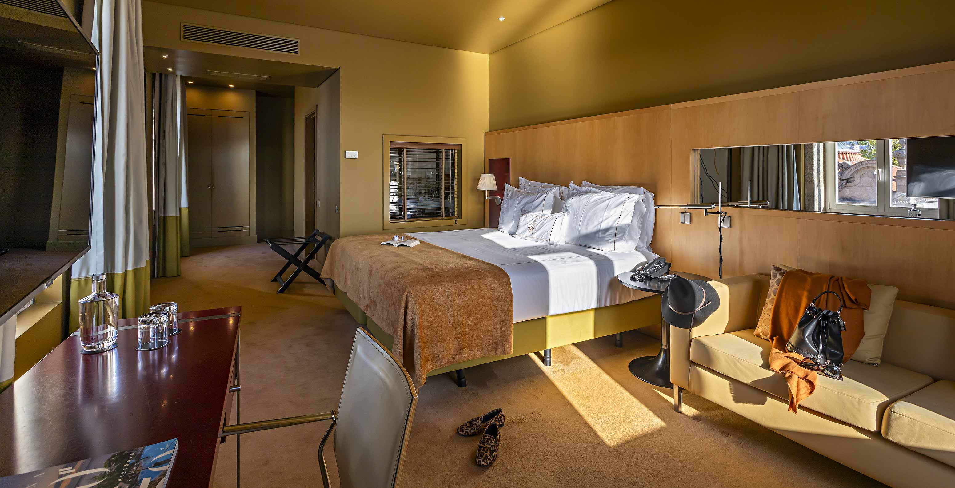 De Deluxe Grand View heeft een tweepersoonsbed met een camel-kleurige deken, een bank en een bureau