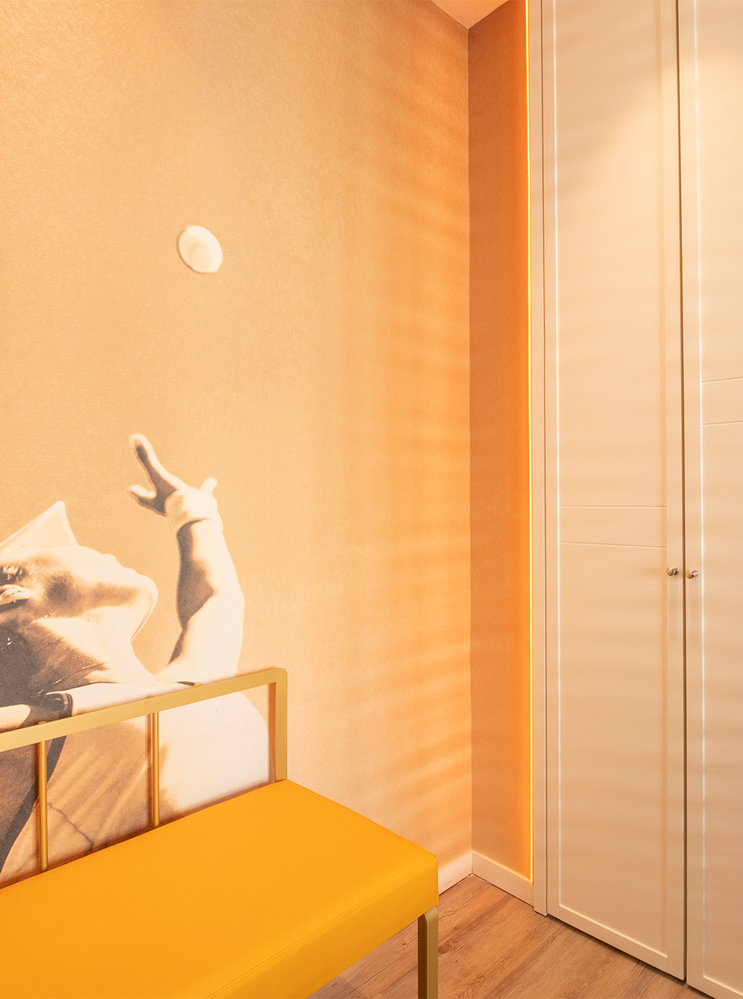 De Legend Room van Pestana CR7 Gran Vía Madrid heeft een kast, een bank en een foto van een tennisser als behang