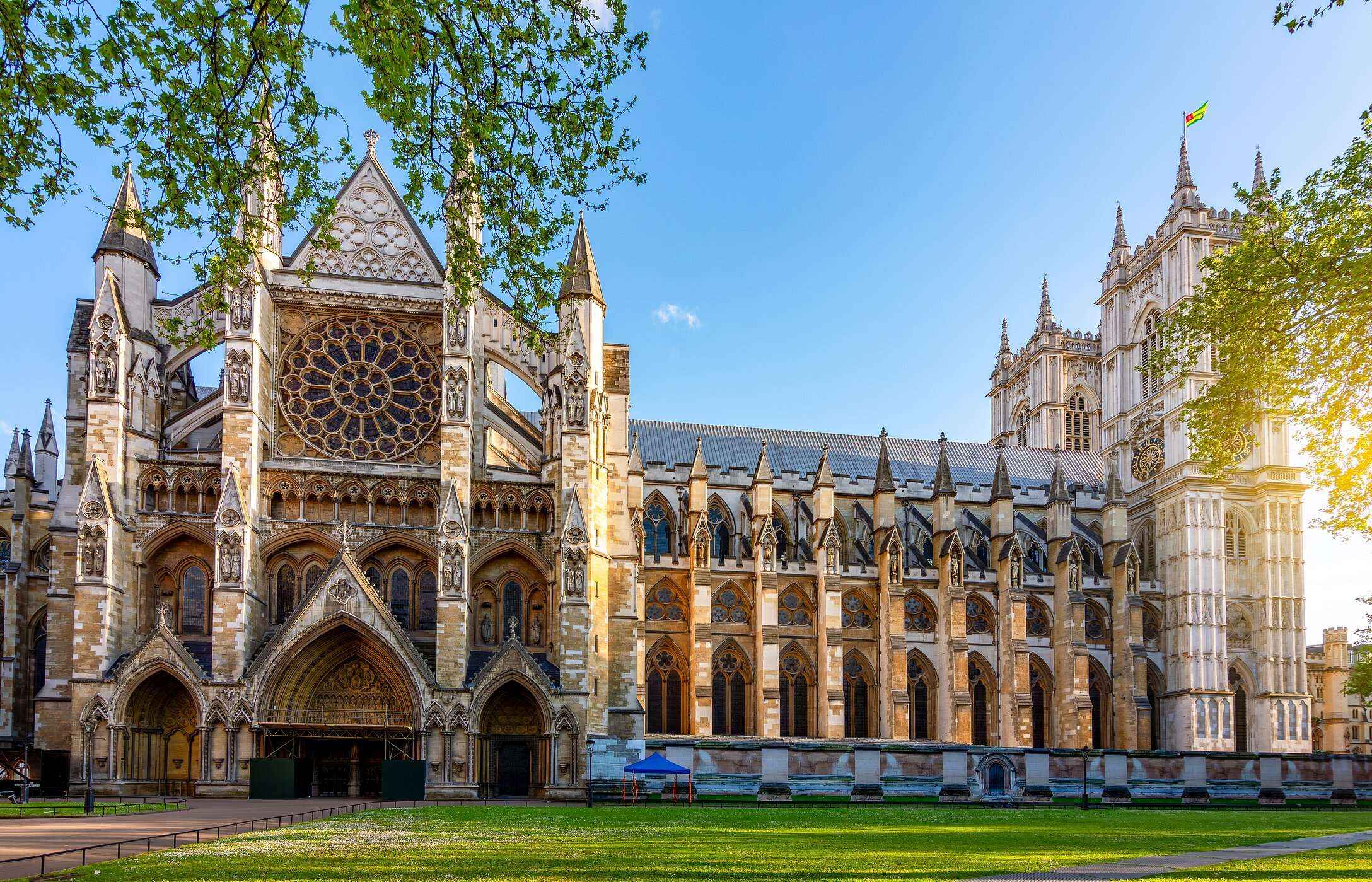 Facade of Westminster Abbey in London, with its Gothic arches, circular stained glass window, and pointed towers.