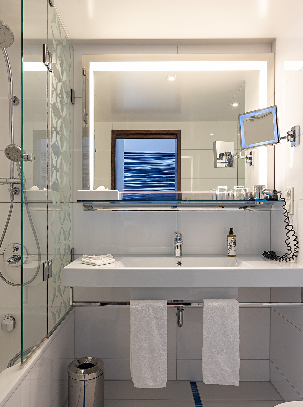 O Quarto Premium com Varanda do Pestana Berlin Tiergarten conta com casa de banho com chuveiro, um lavatório e um espelho