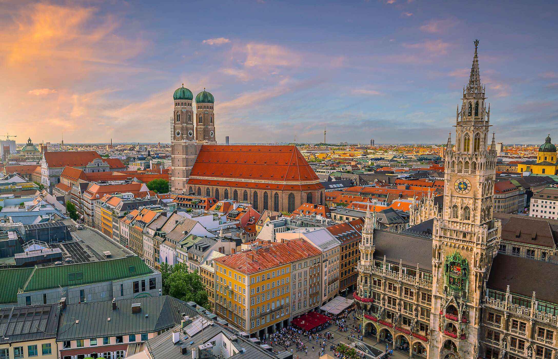 Vista aérea da Marienplatz em Munique, na Alemanha, com uma arquitetura gótica, edifícios à volta e várias pessoas a passear 