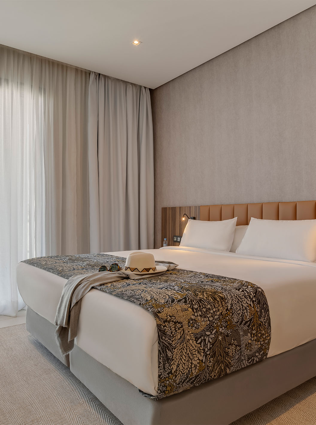 A Suite Familiar Corniche do Pestana Casablanca tem um quarto com uma cama de casal com uma decoração moderna