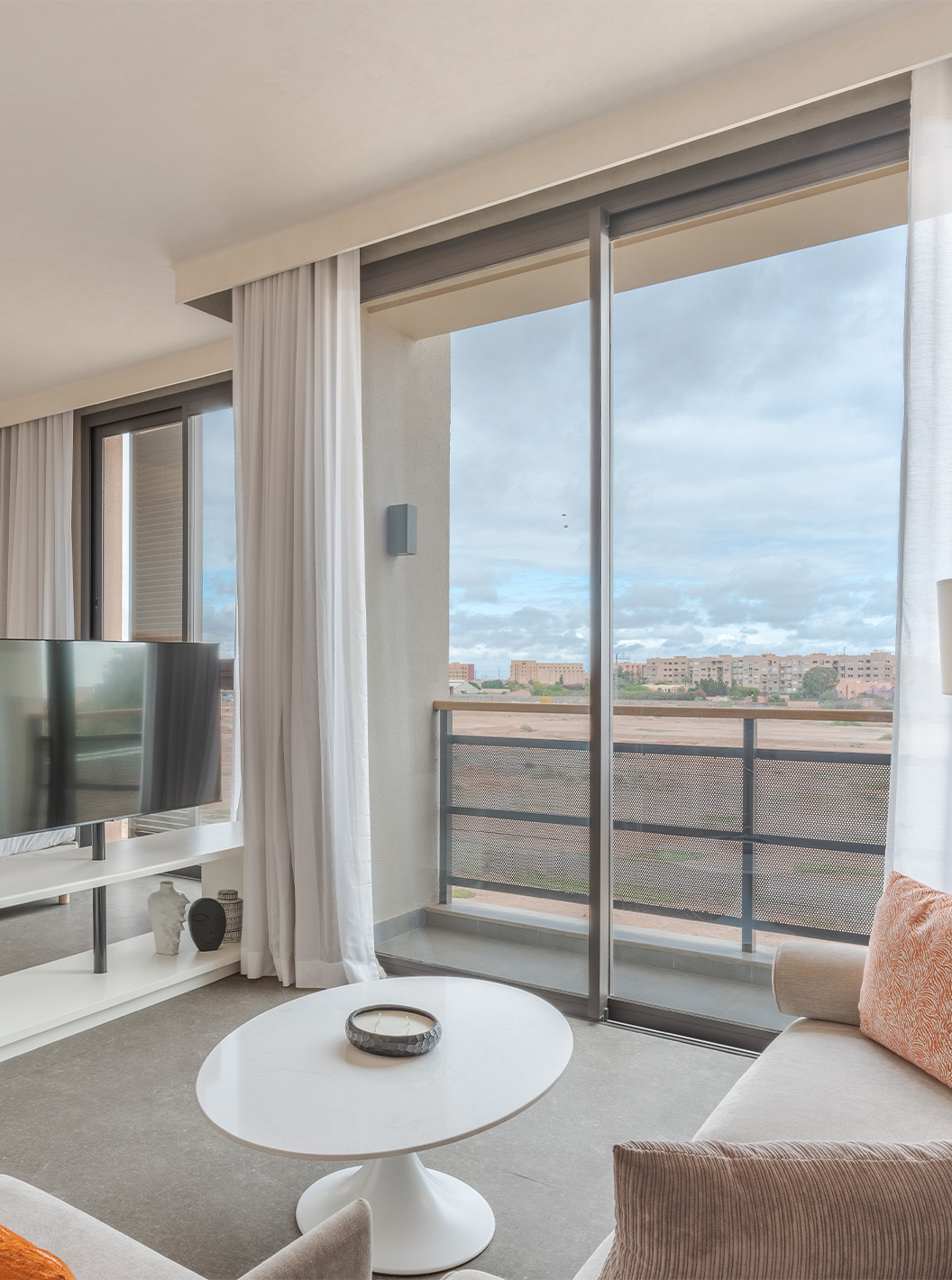 A CR7 Junior Suite do Pestana CR7 Marrakech tem uma varanda e uma zona de estar dentro do quarto, com sofás e televisão