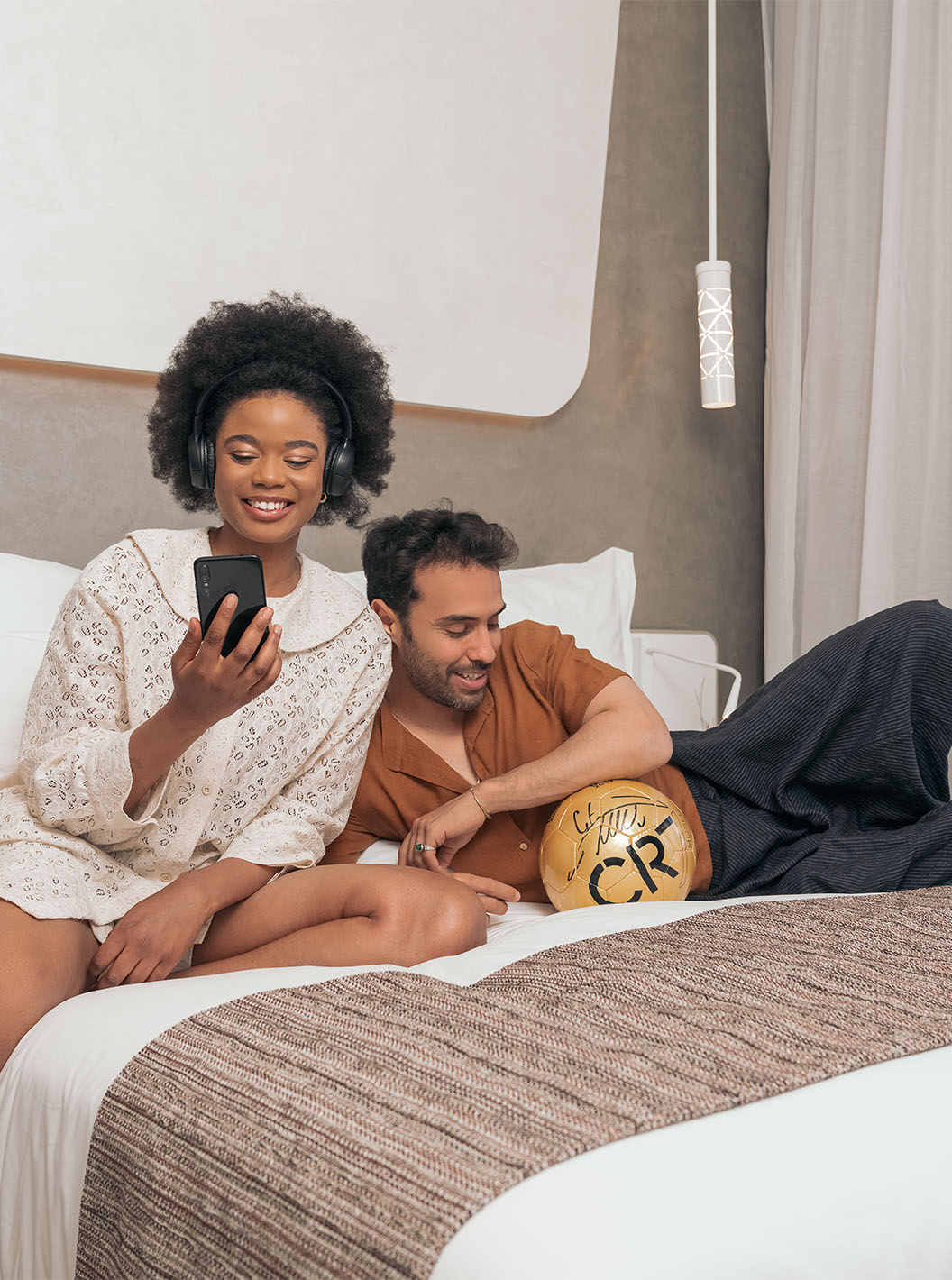 O CR7 Superior do Pestana CR7 Marrakech tem uma cama de casal com um casal sorridente, com uma bola de futebol do CR7