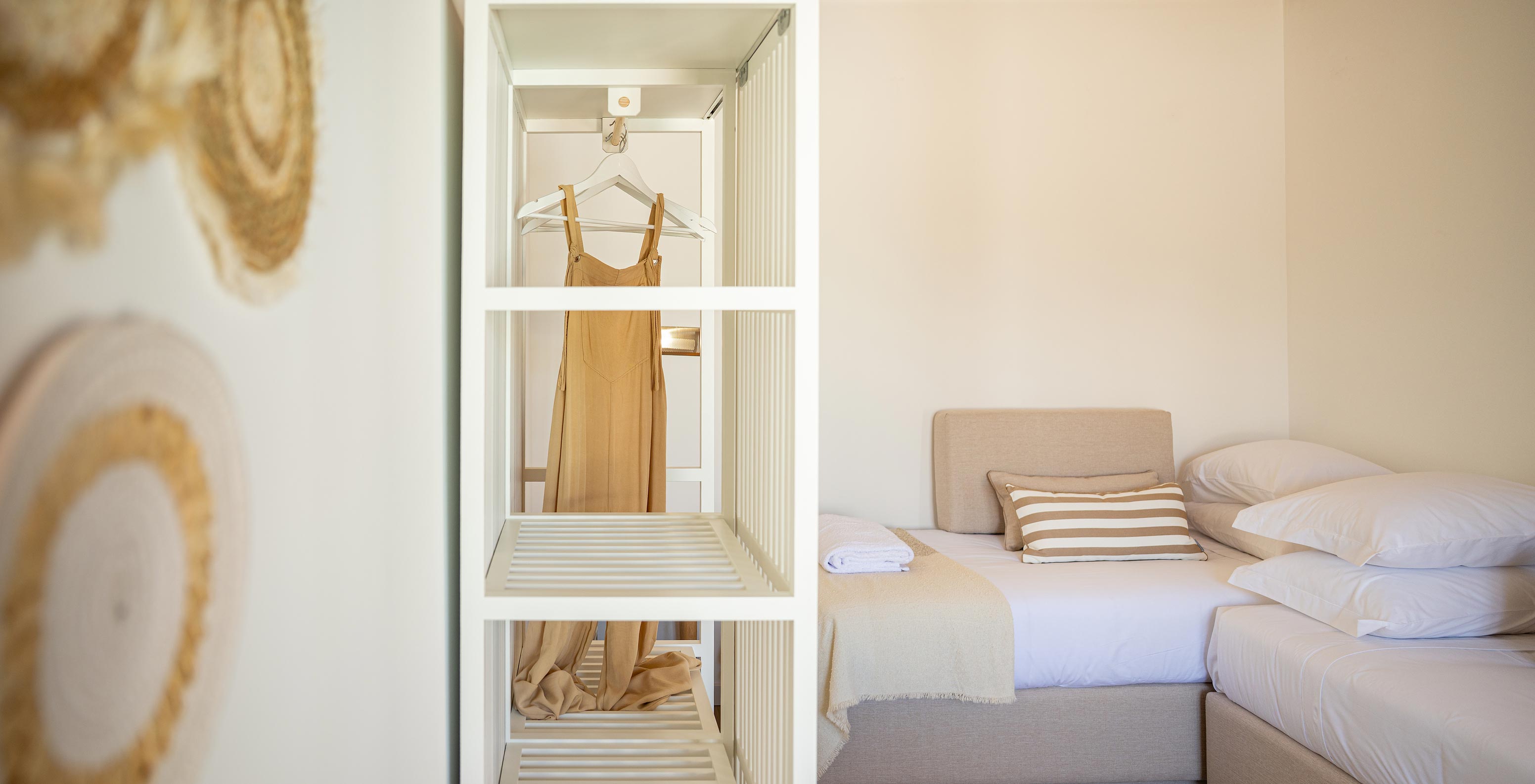 A Standard Villa do Pestana Comporta Village Residences tem um closet com um roupeiro branco e decoração de palha