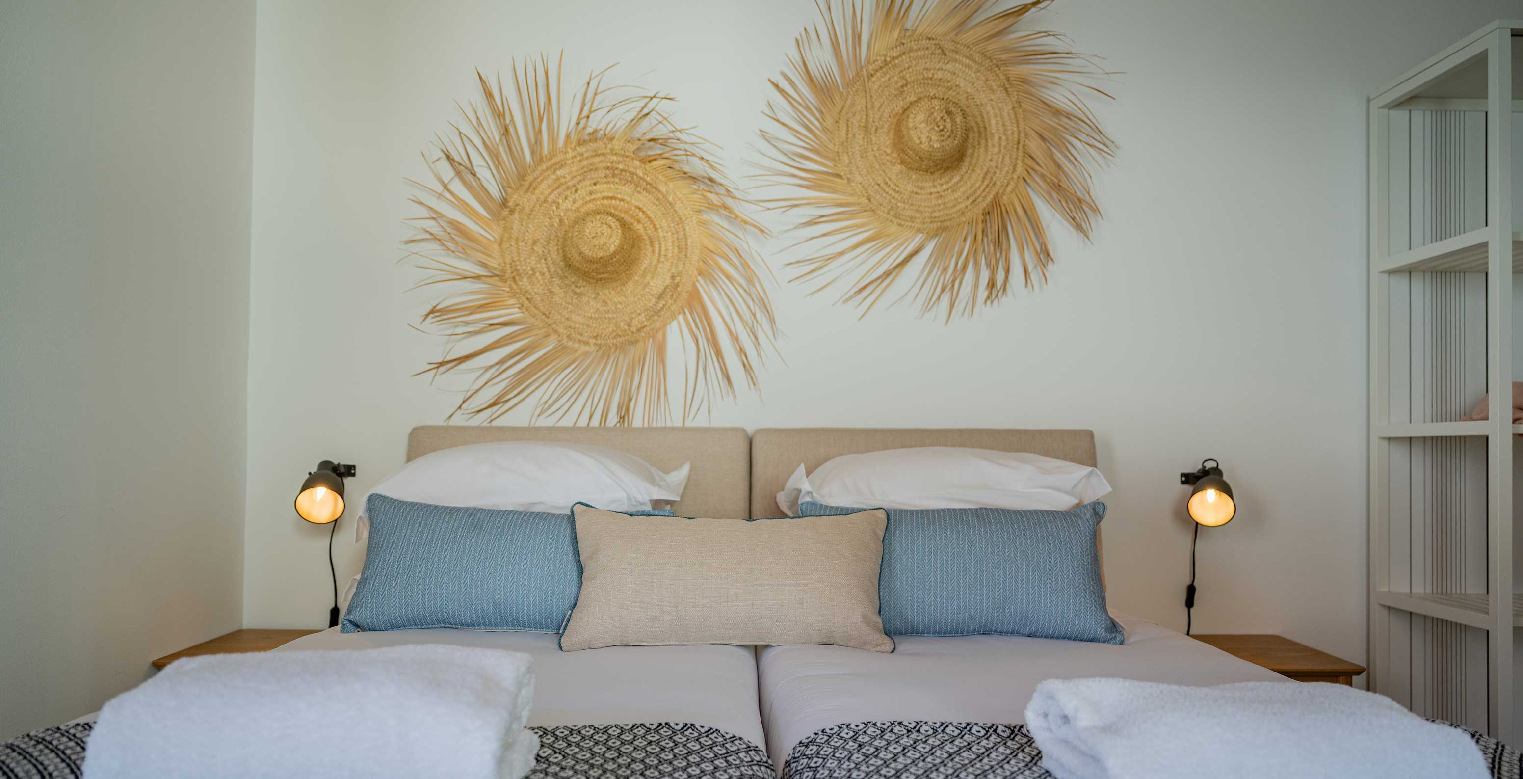 A Standard Villa do Pestana Comporta Village Residences tem uma cama de casal com decoração de palha na parede