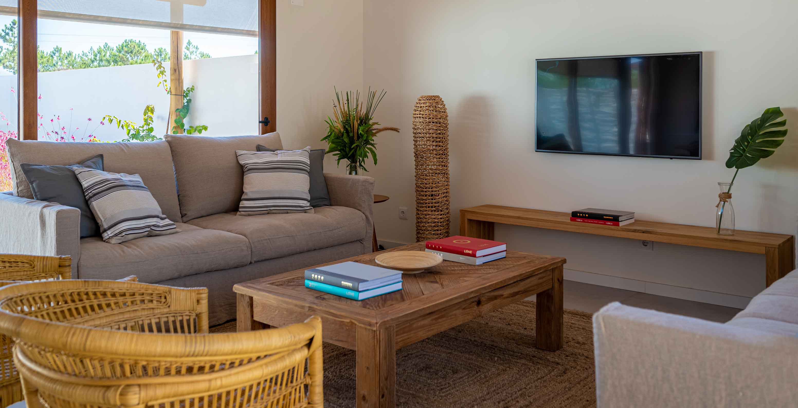 A Standard Villa T1 do Pestana Comporta Village Residences tem uma sala de estar com um sofá e uma TV na parede