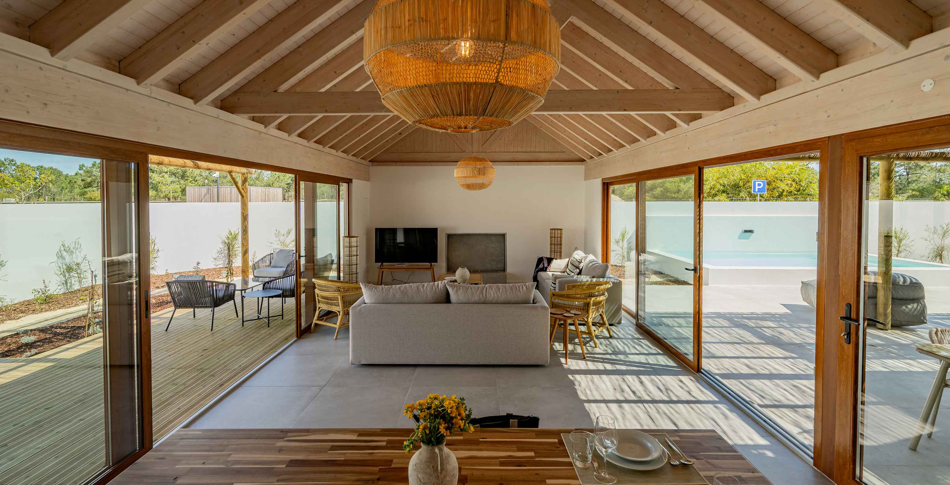 A Premium Green Villa do Pestana Comporta Village Residences tem uma sala de estar moderna com janelas amplas e uma mesa