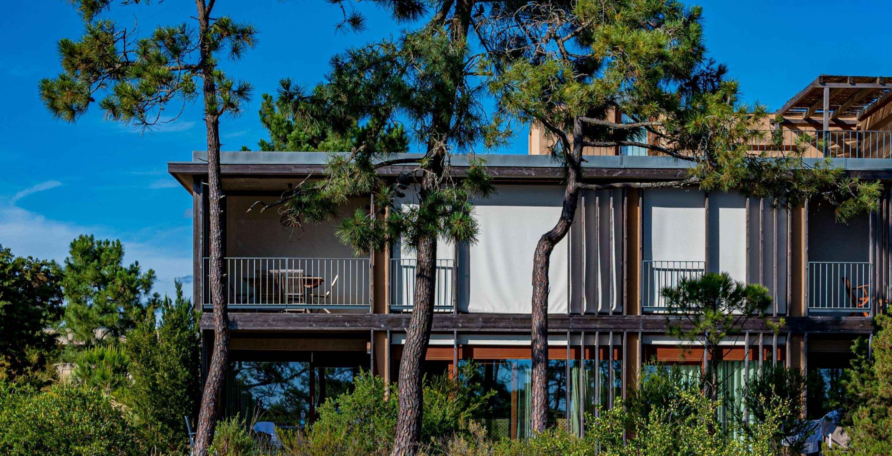 O Apartamento Eco Village Superior 1º Andar Vistas Premium do Pestana Tróia Eco Resort tem árvores à volta da villa