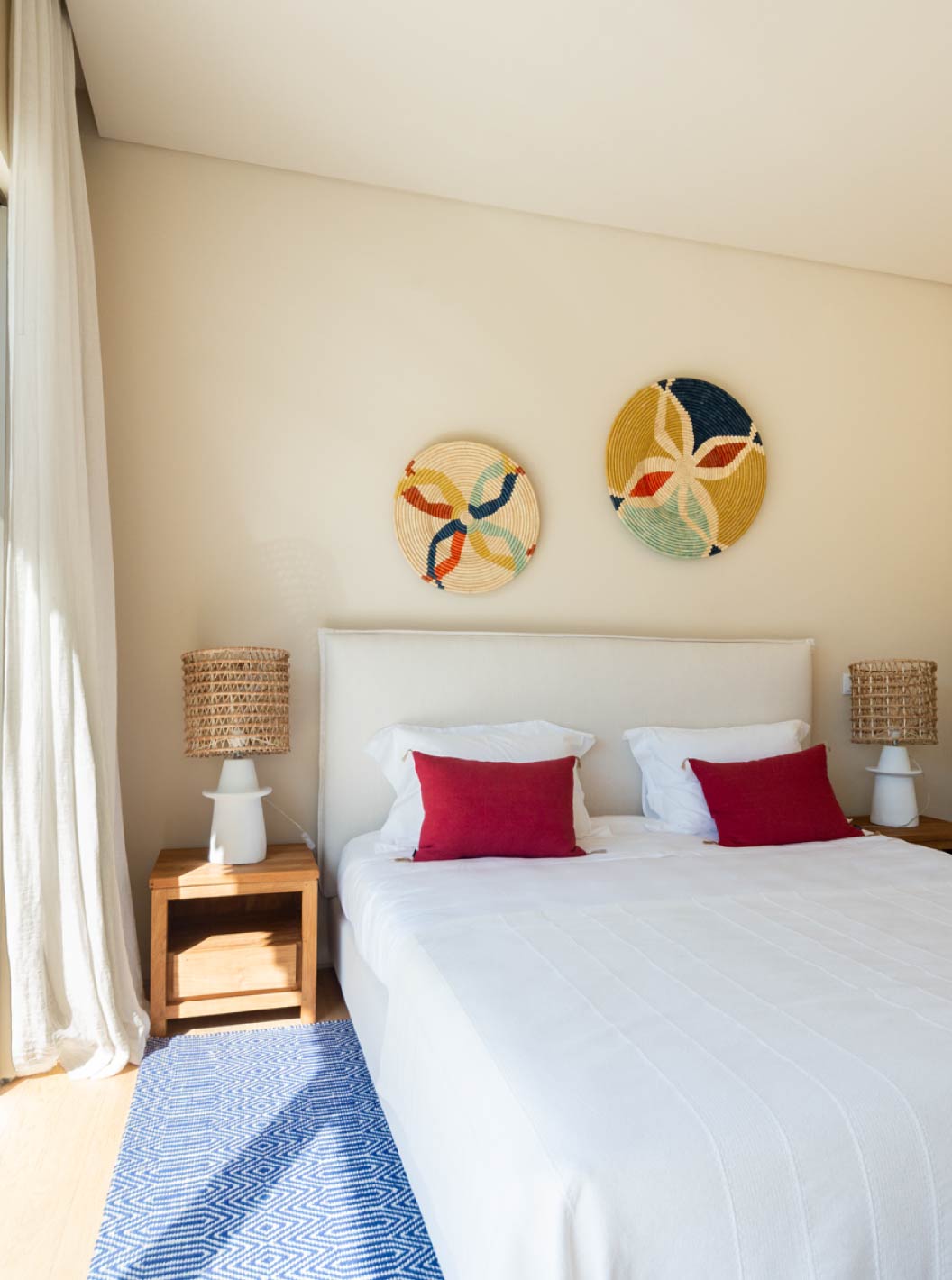 A Villa exclusiva com piscina do Pestana Tróia Eco Resort tem um quarto com cama de casal, almofadas vermelhas e tapete azul