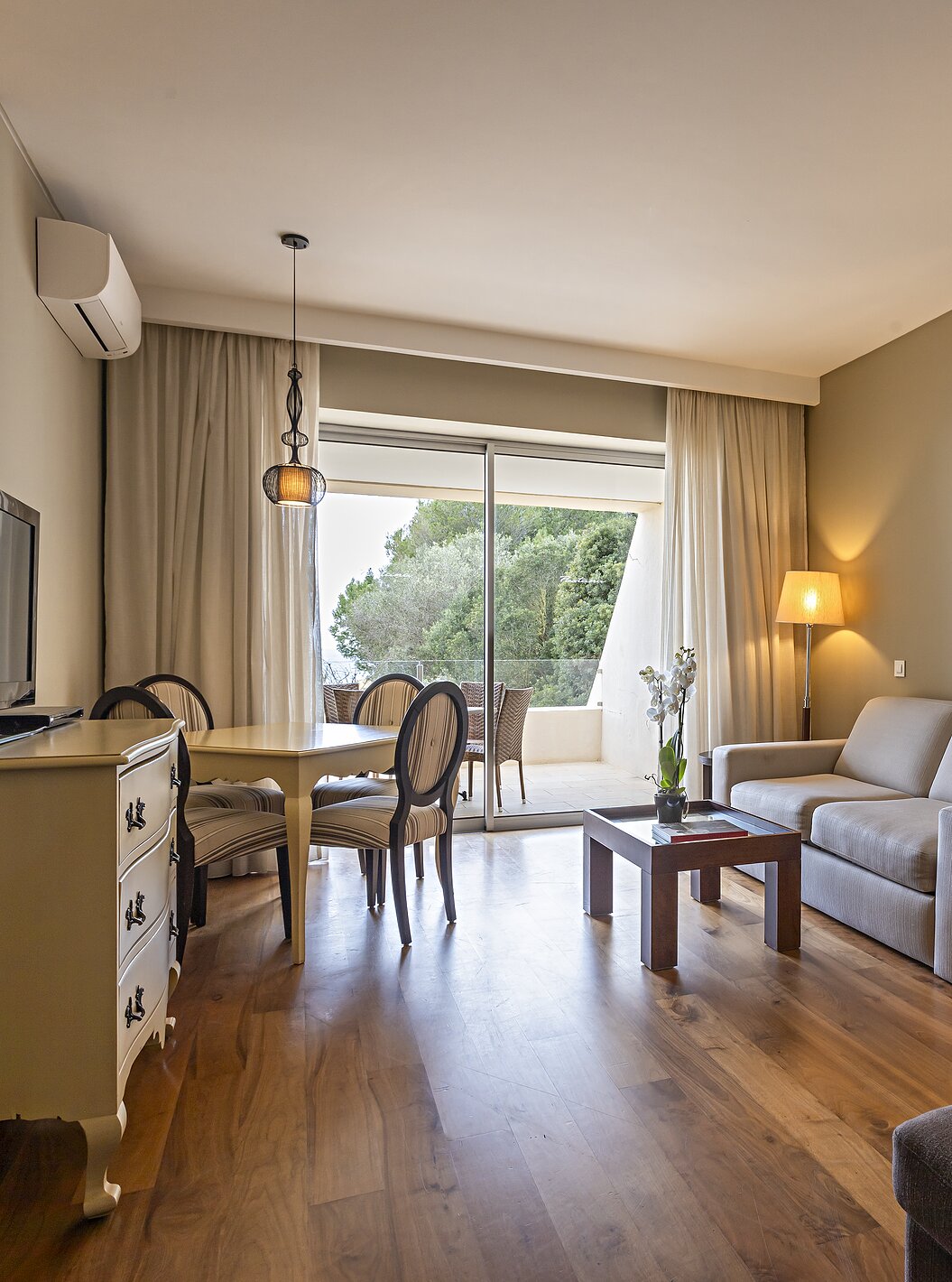A Cliff Suite T1 do Pestana Alvor Praia tem uma sala com dois sofás, uma cómoda com televisão, uma mesa de jantar e cadeiras