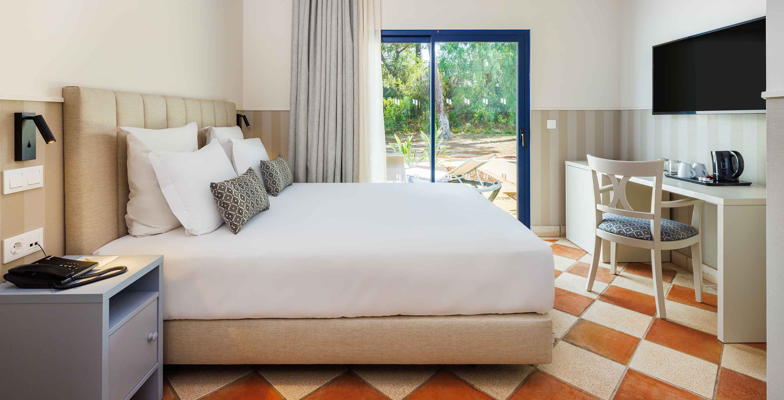 O Clássico Vista Jardim do Pestana Vila Sol - Vilamoura tem uma cama de casal, uma secretária com uma cadeira e janela com varanda