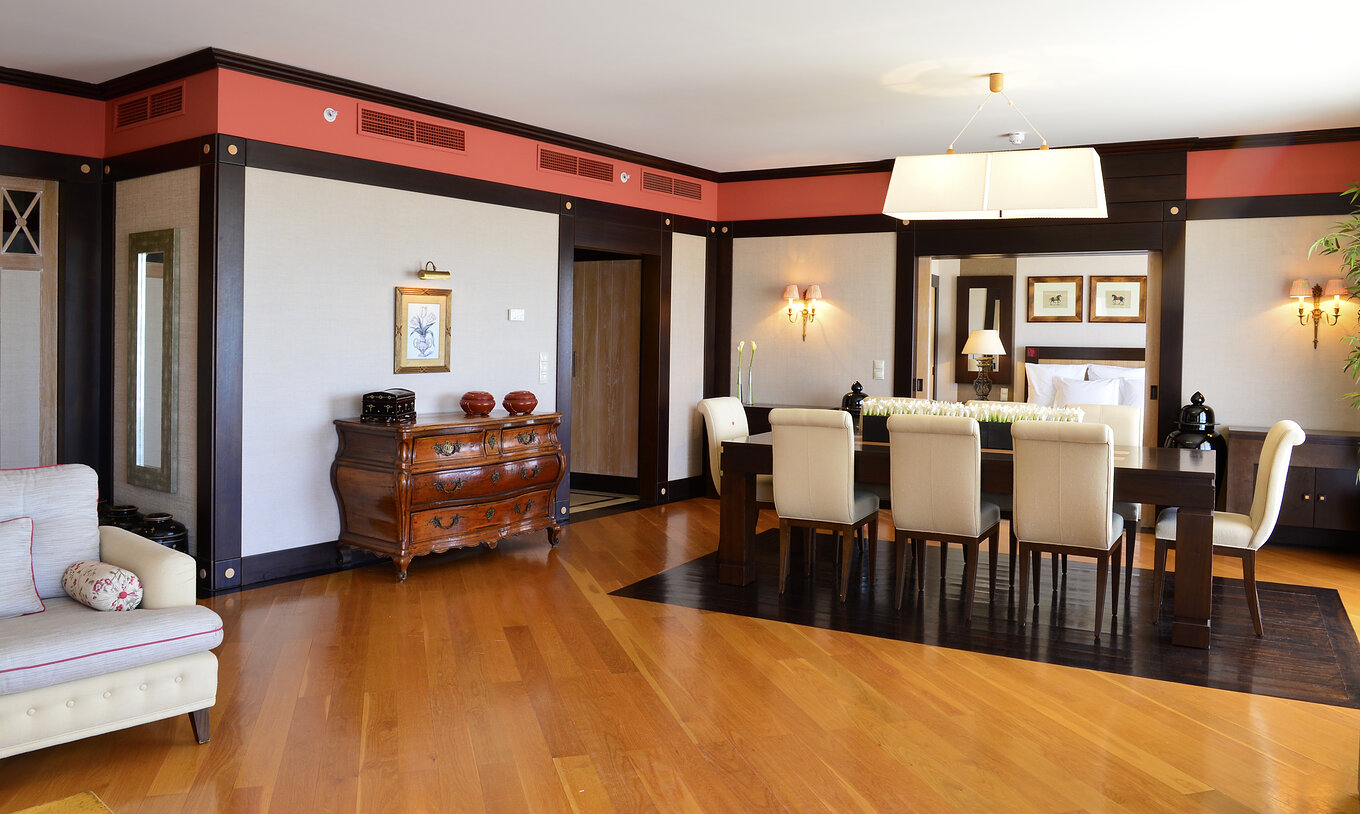 A Suite Presidencial do Pestana Vila Sol - Vilamoura tem uma sala ampla com uma mesa de jantar e um aparador em madeira