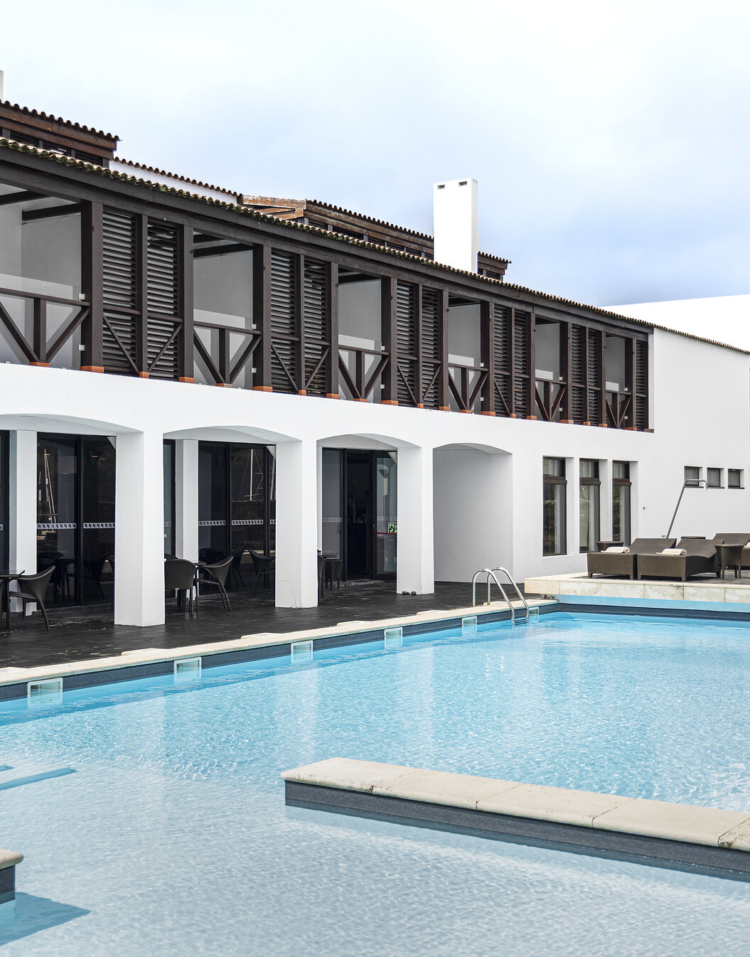 Vista exterior da Pousada Forte Horta, onde se encontra a piscina exterior e as varandas dos quartos com vista para a piscina