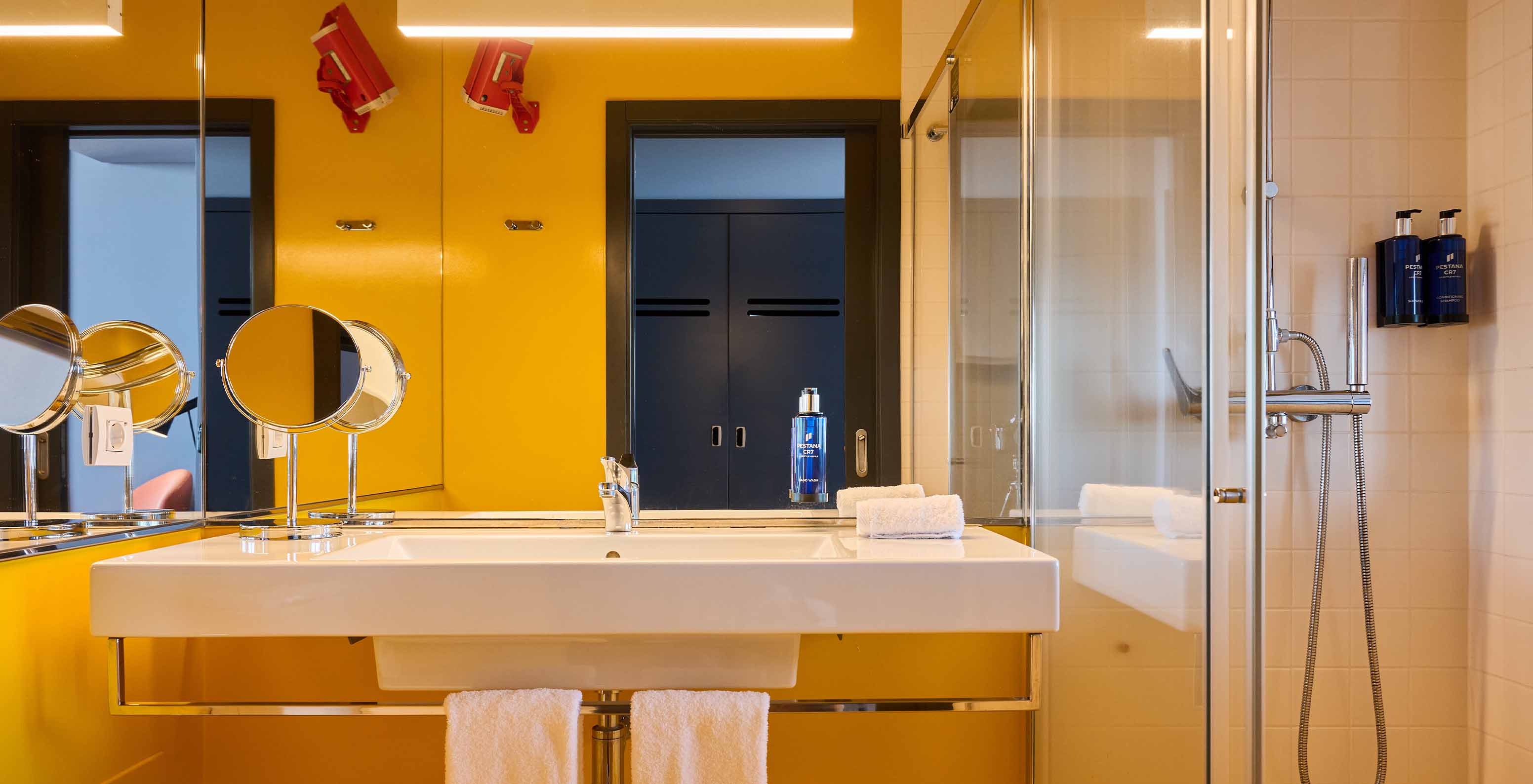 O Quarto CR Superior do Pestana CR7 Funchal tem uma casa de banho com ar moderno, em tons de amarelo, um chuveiro