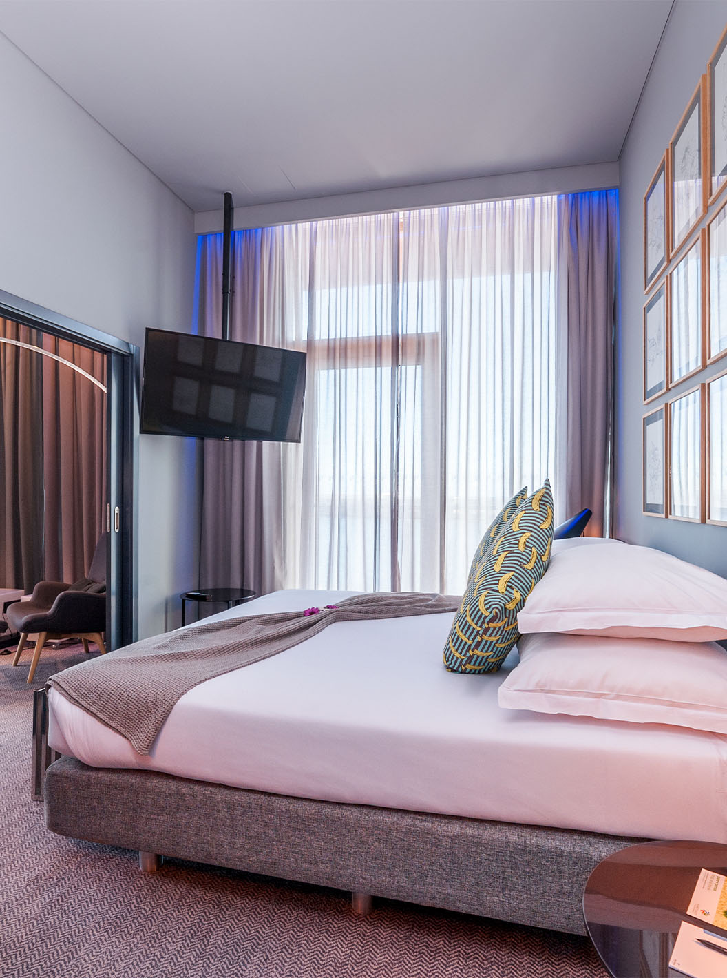 A CR7 Suite do Pestana CR7 Funchal tem um quarto co uma cama de casal, uma televisão presa na parede e uma janela