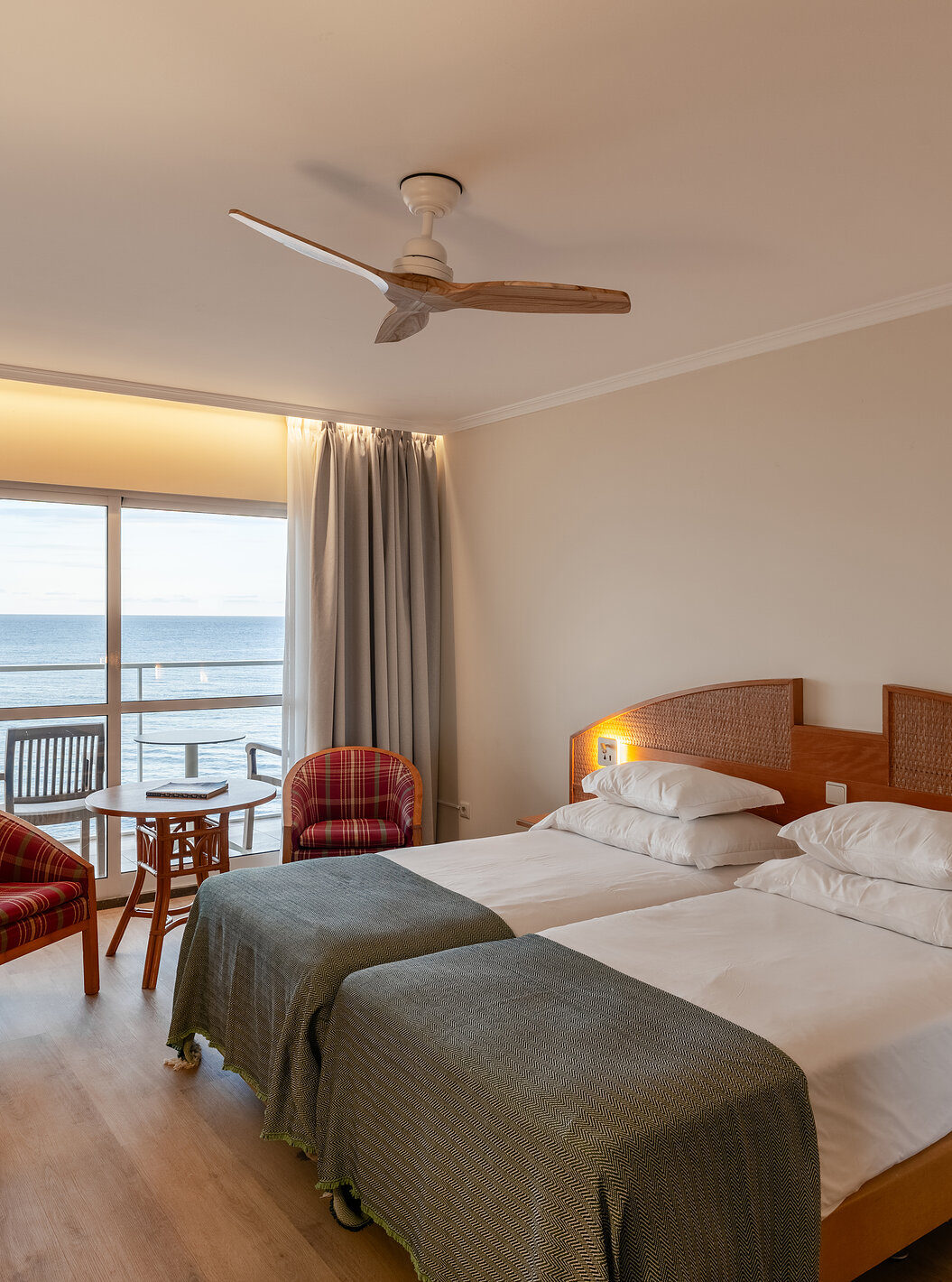 O Superior Sea View do Pestana Ocean Bay All Inclusive tem uma cama dupla com uma colcha verde e varanda com vista mar 