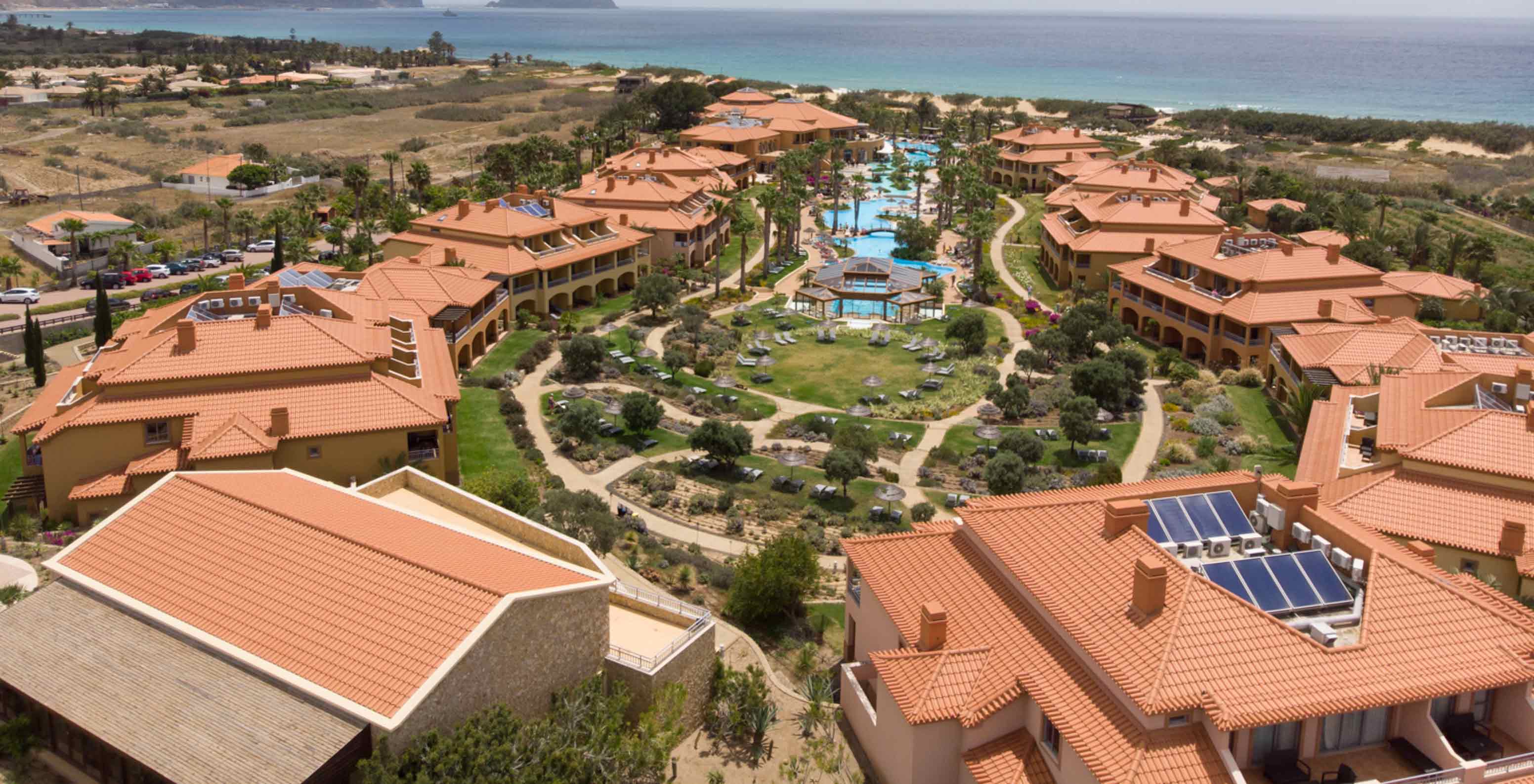 Vista de drone do Pestana Porto Santo All Inclusive, com várias villas em redor da piscina e da vegetação