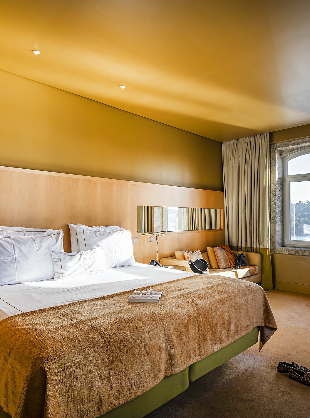 O Deluxe Grand View do Pestana Palácio do Freixo tem uma cama de casal e uma janela em pedra com vista para o rio Douro