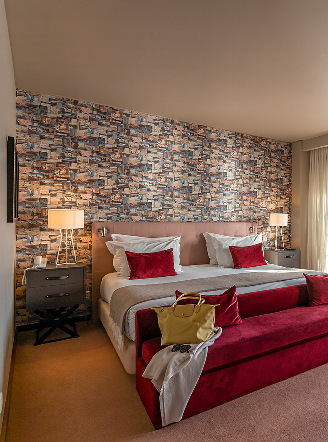 A Suite Grand View do Pestana Vintage Porto tem uma cama de casal, um sofá vermelho e janelas com vista para o Porto