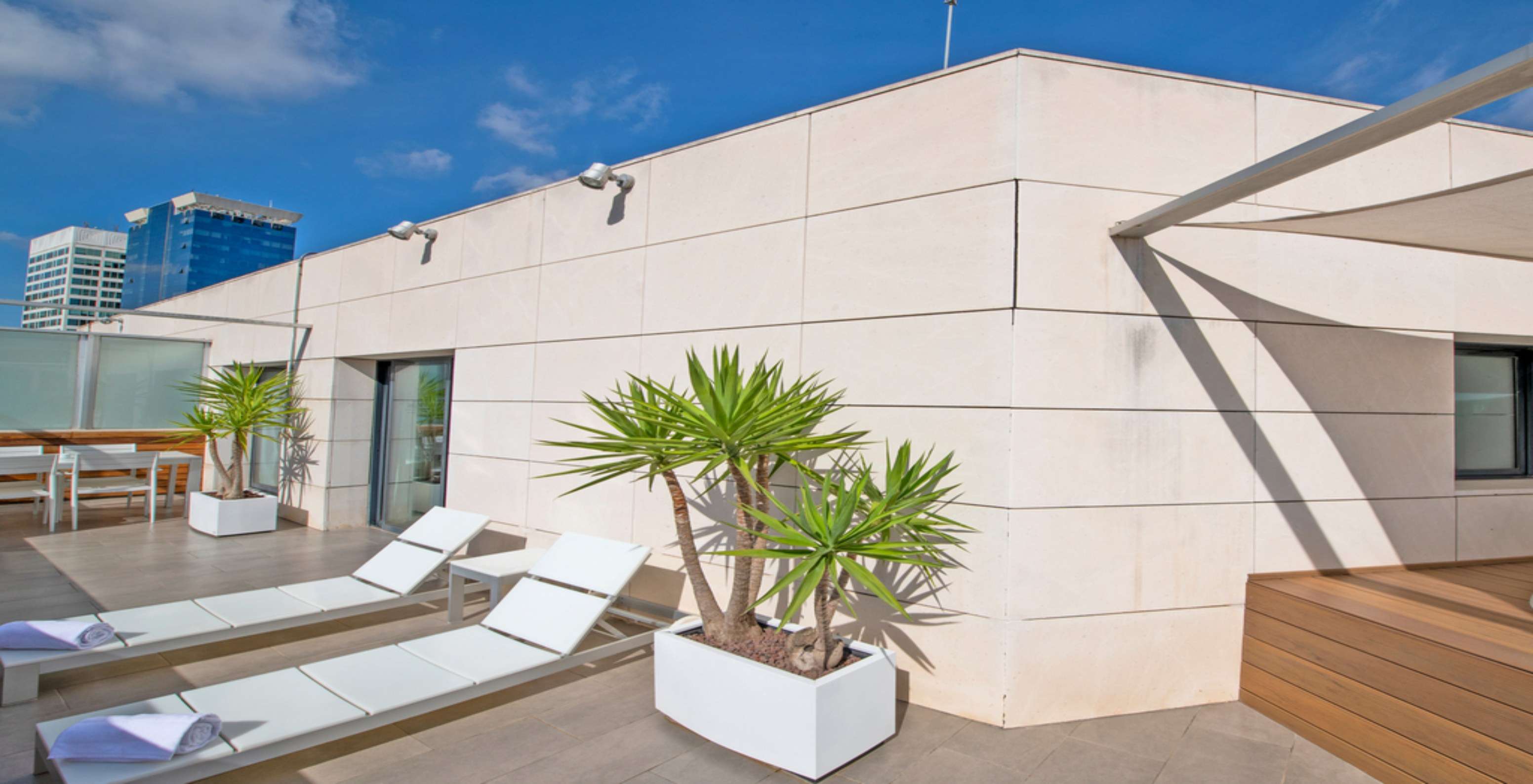 A Junior Suite do Pestana Arena Barcelona tem um terraço no rooftop com espreguiçadeiras e plantas para relaxar