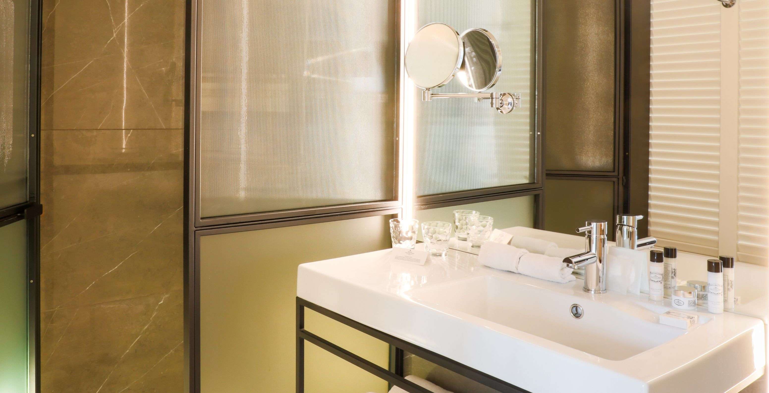 O Quarto Superior Plus do Pestana Collection Plaza Mayor tem uma casa de banho com espelho grande e um chuveiro walk-in