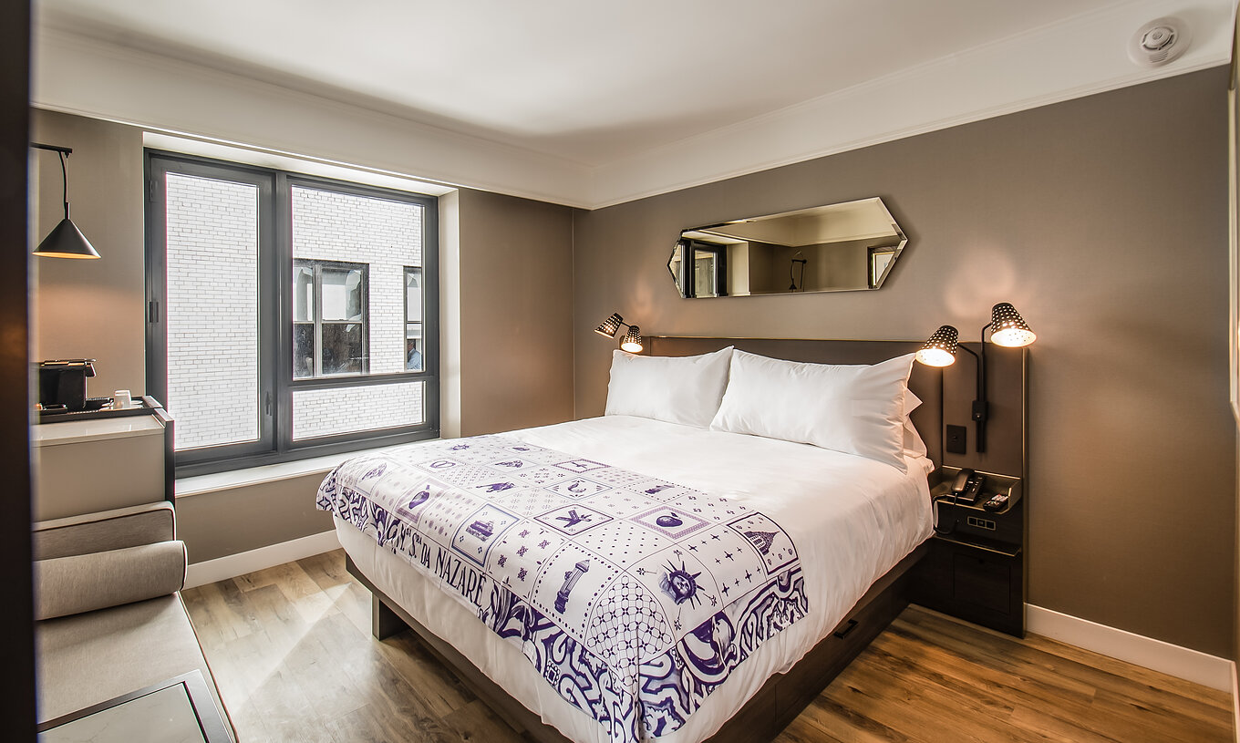 O quarto Clássico - ADA do Pestana Park Avenue conta com uma cama de casal, com mesa de cabeceira com candeeiro e telefone