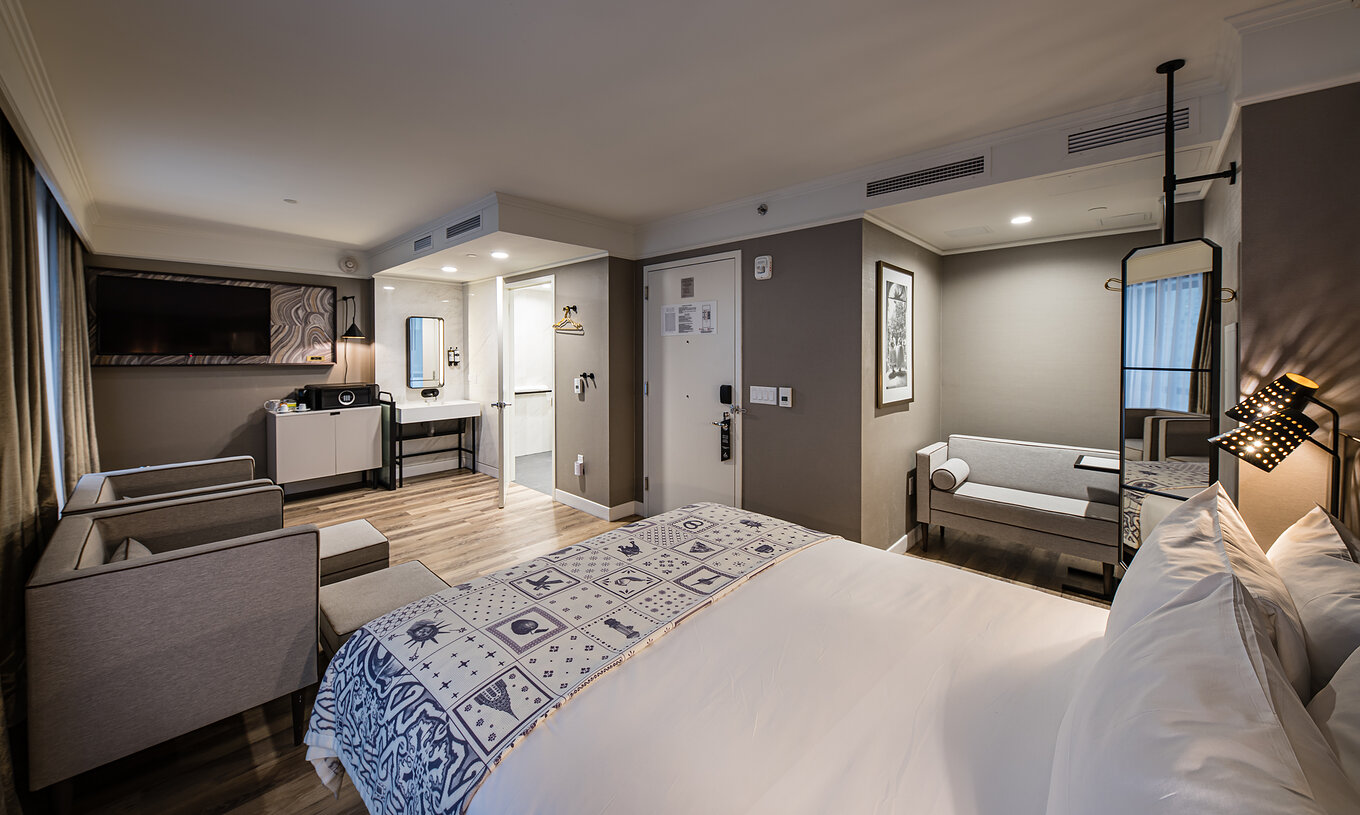 A Junior Suite - ADA do Pestana Park Avenue conta com uma sala de estar com sofá e cadeirões, cofre e televisão