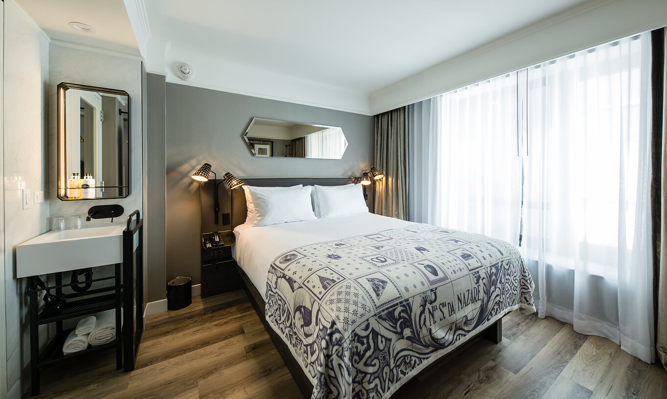 O quarto Superior do Pestana Park Avenue conta com uma cama de casal, com lavatório e espelho no quarto, e mesa de cabeceira