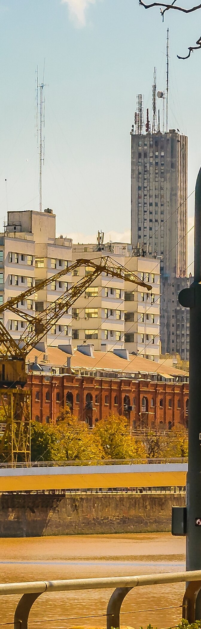 Paisagem urbana de Buenos Aires com o bairro portuário de Puerto Madero, com edifícios altos e um rio Prata